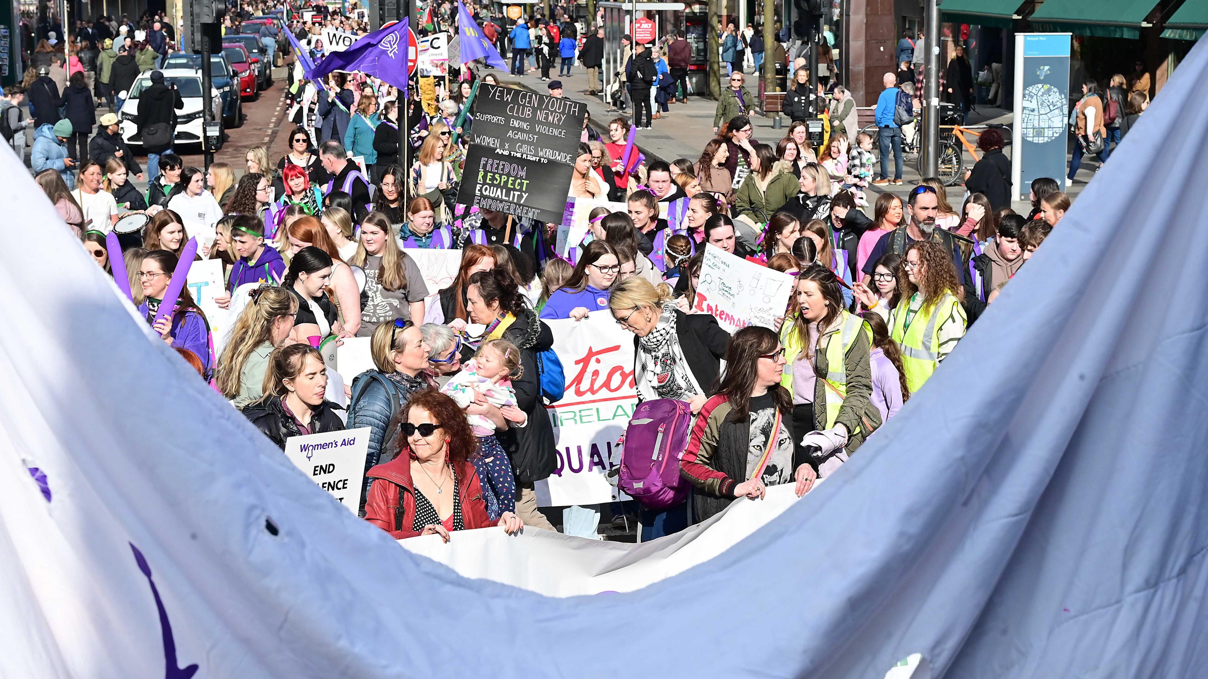 A group of people some holding placards who attended a march in Newry on International Women's Day 