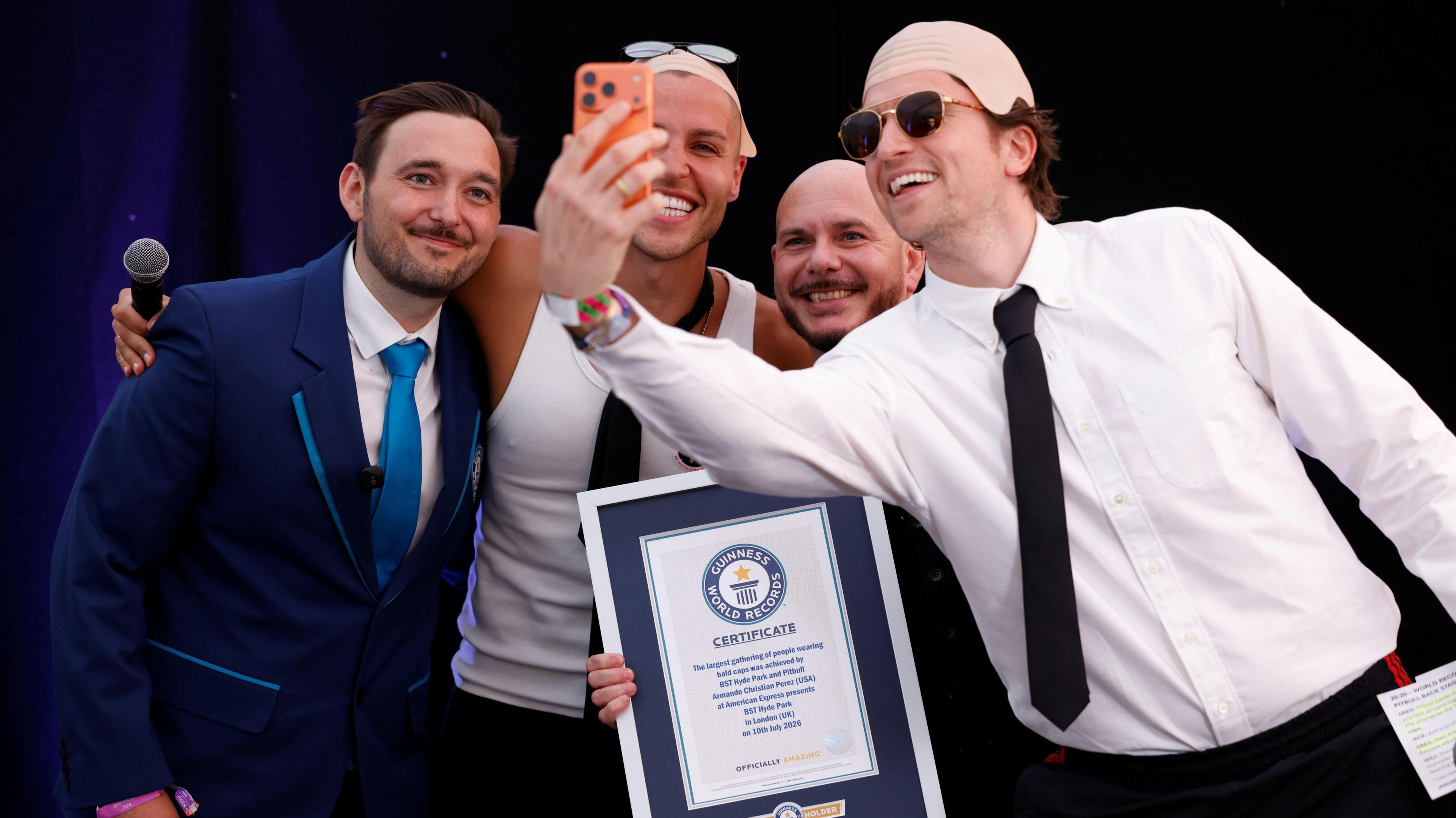 Guinness World Record ajudicator Will, content creator Jack Remmington, Pitbull and BBC Radio 1 Breakfast presenter Greg James pose for a selfie photo.