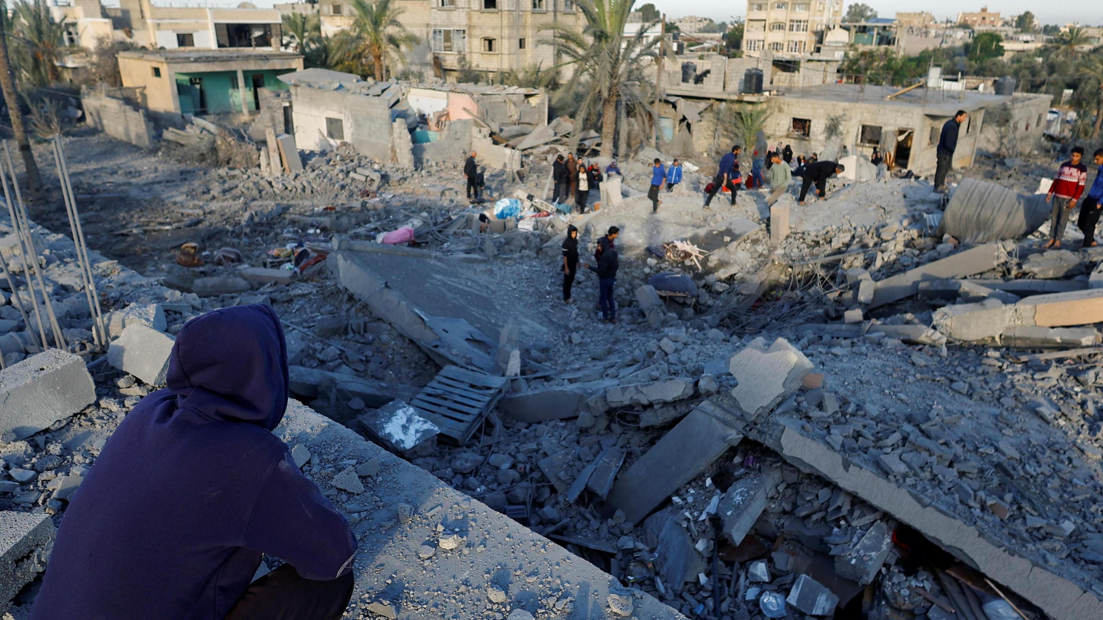 Palestinians inspect buildings destroyed in an Israeli strike in Khan Younis, in the southern Gaza Strip (25 October 2024)