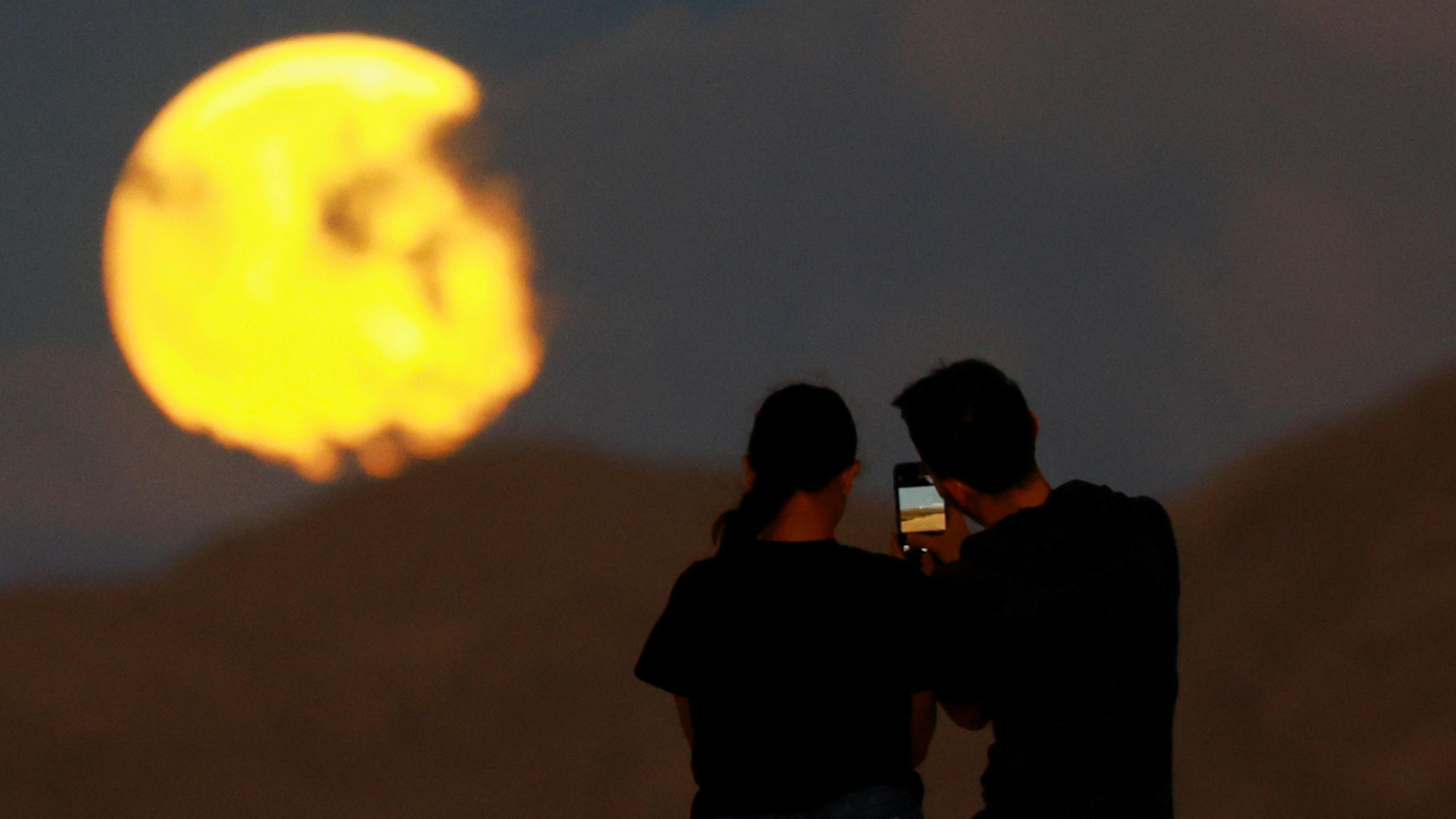 two people taking a picture of supermoon in Mexico