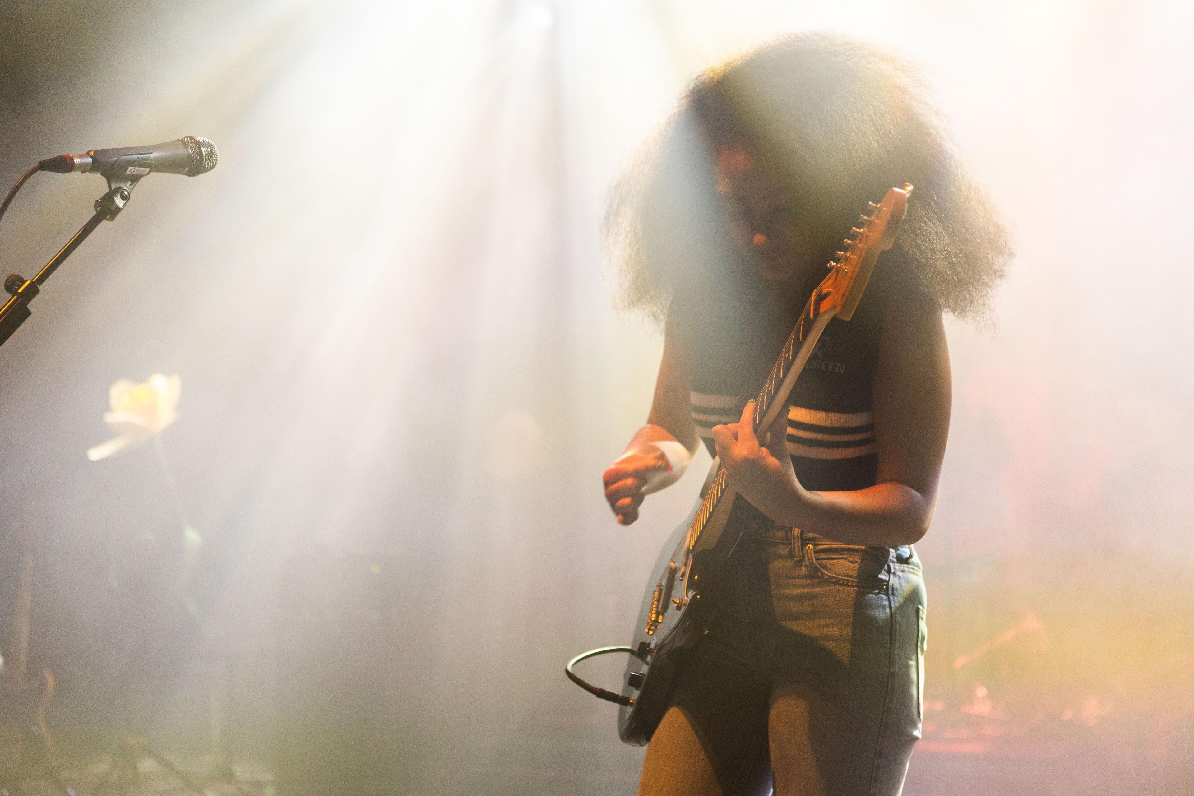 Lily Fontaine of English Teacher strums an electric guitar while on stage during a concert at London's Shepherd's Bush Empire in November 2024