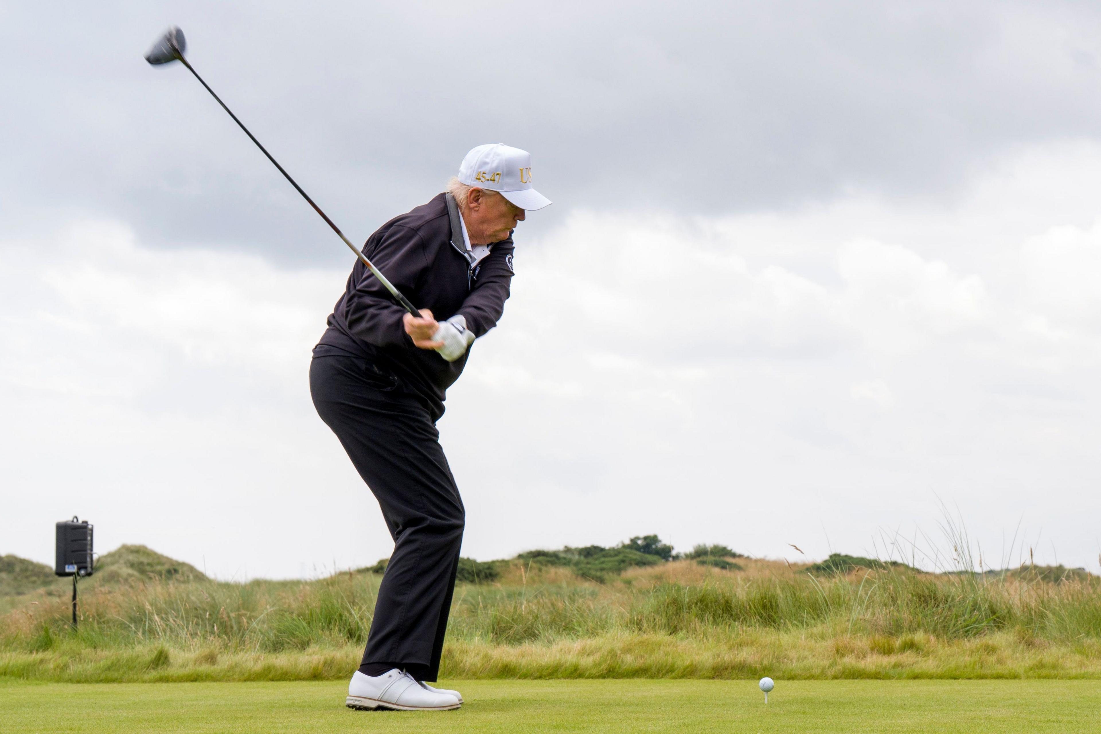 Guests watch Donald Trump tee off at his new golf course in Aberdeenshire.