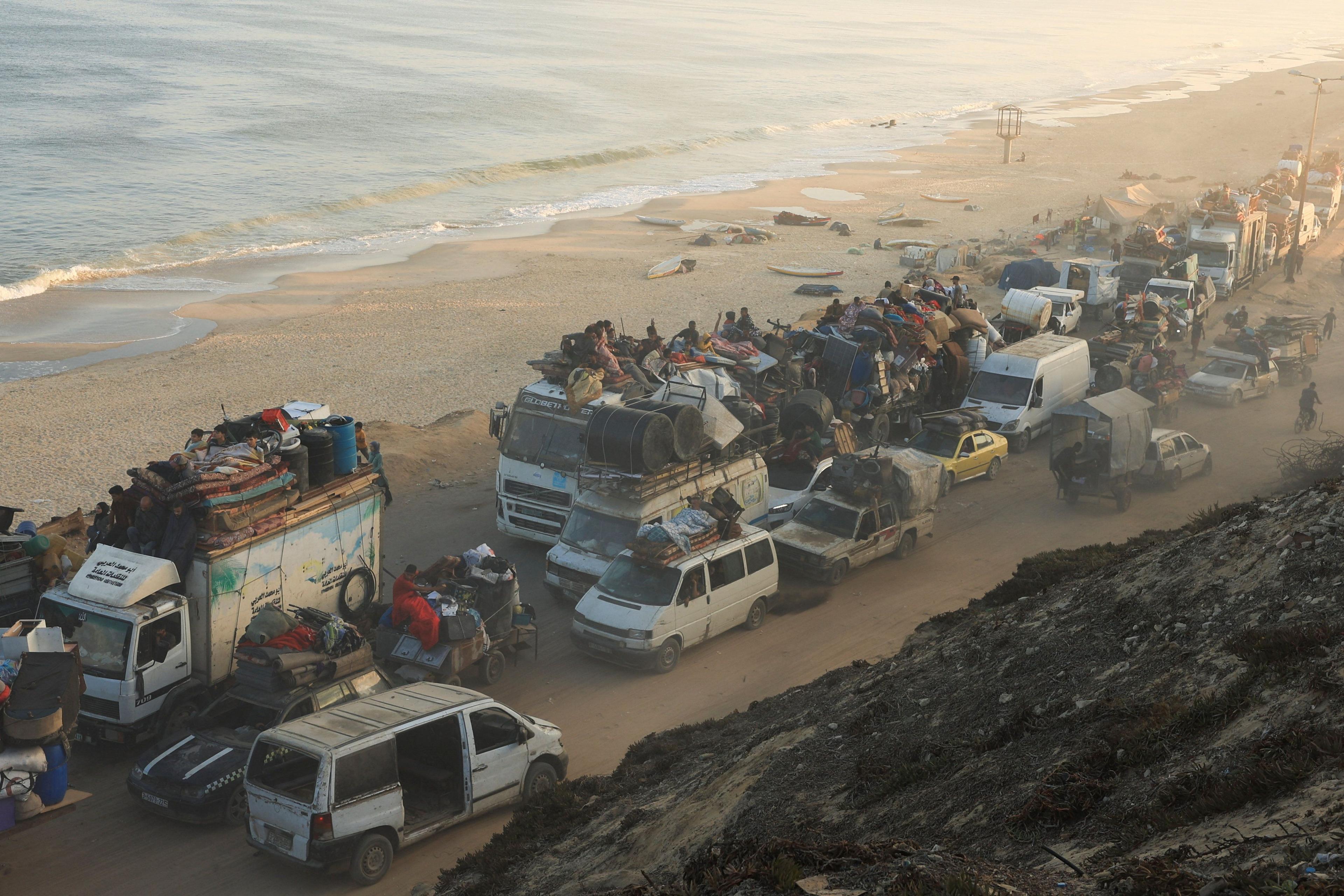 Displaced Palestinians, fleeing northern Gaza, move southward in cars, trucks and on bikes