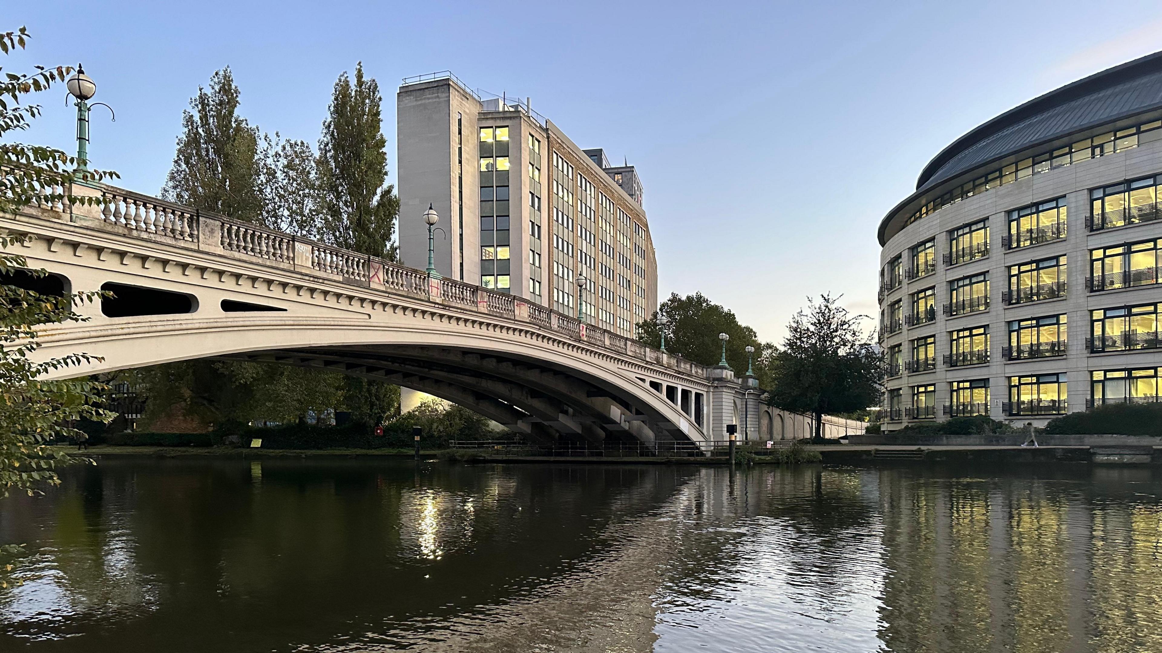 A bridge over the River Thames in Caversham with two high rise buildings dominating the skyline 