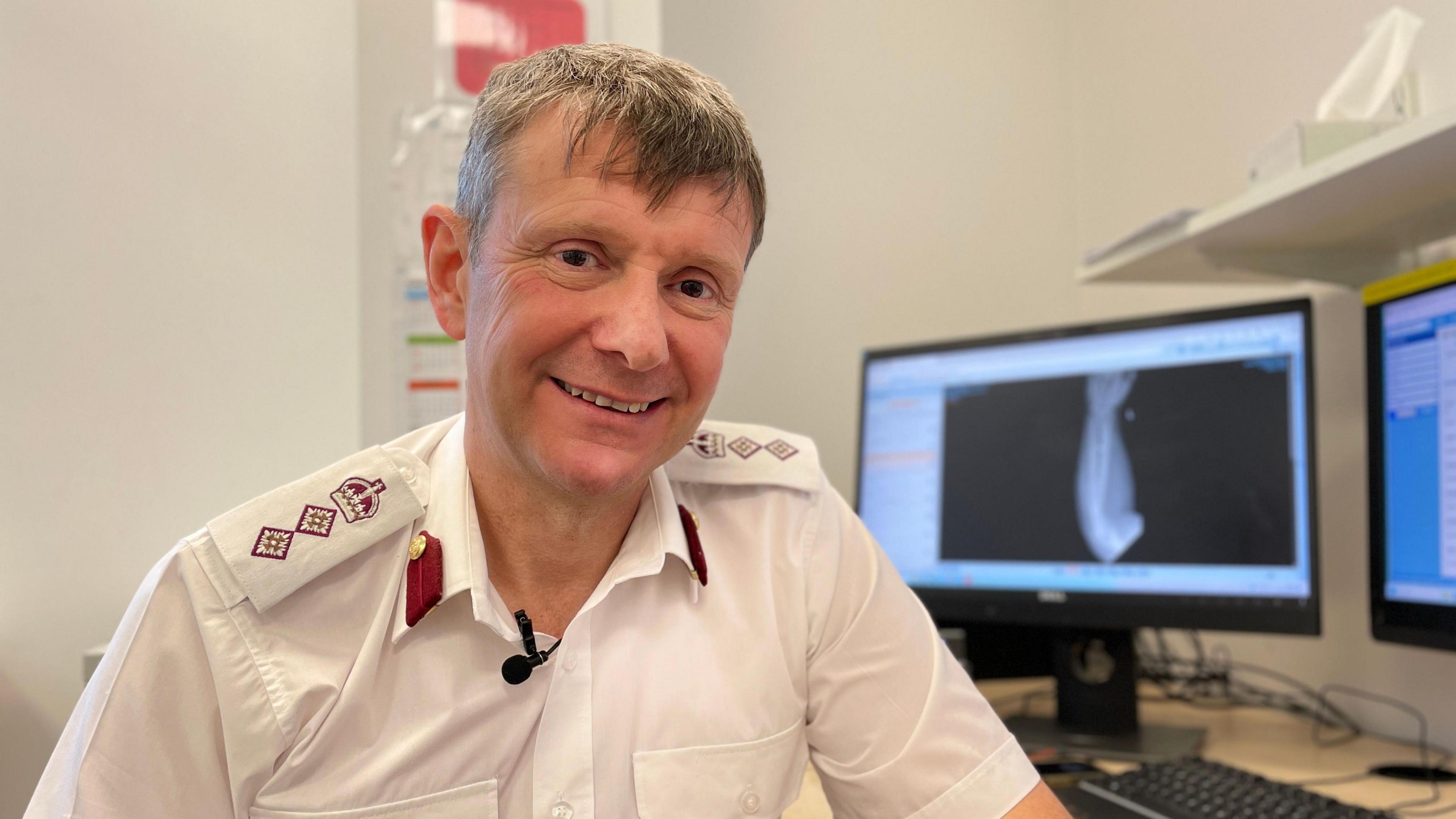 Colonel Mark Foster, hand and plastic surgeon at the Queen Elizabeth Hospital sits in his office with an X-ray of Matt Davies' left arm on the computer screen behind him.