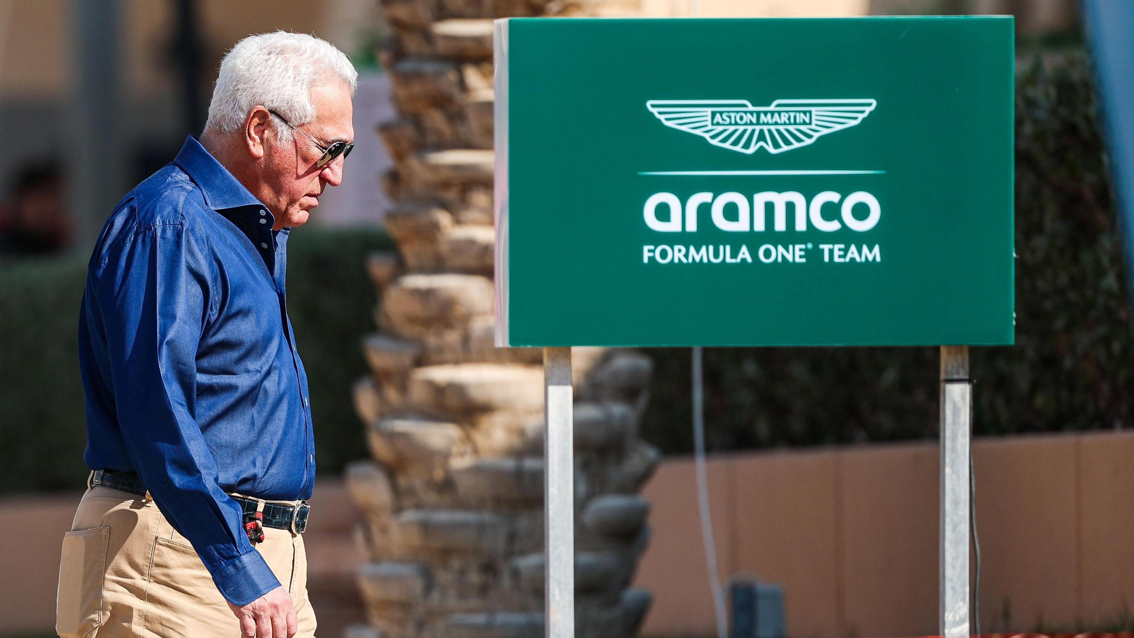 Aston Martin team owner Lawrence Stroll walks with his head down during Bahrain testing