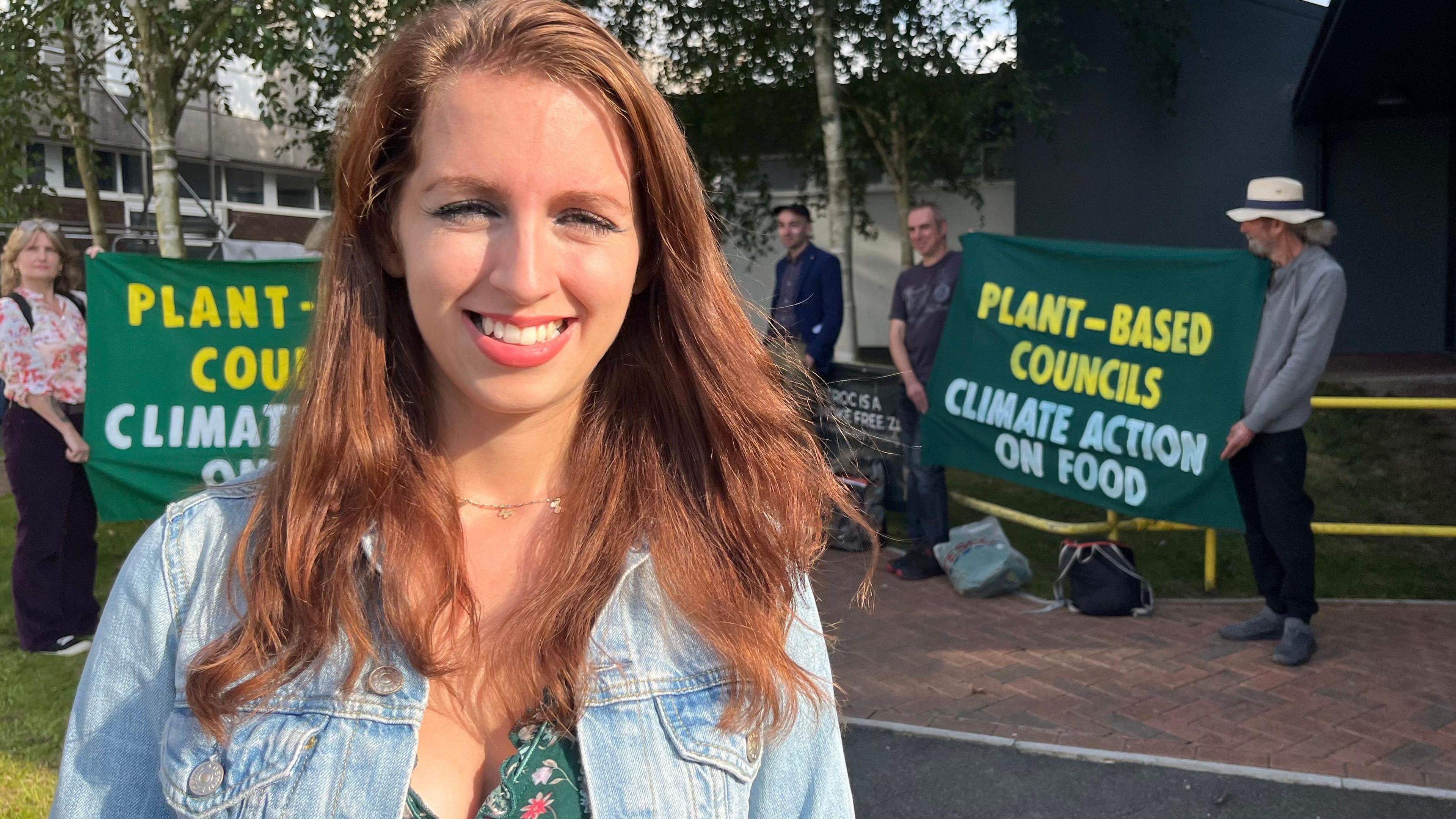 Michaela Andrews from Plant-Based Councils standing in front of campaigners holding signs