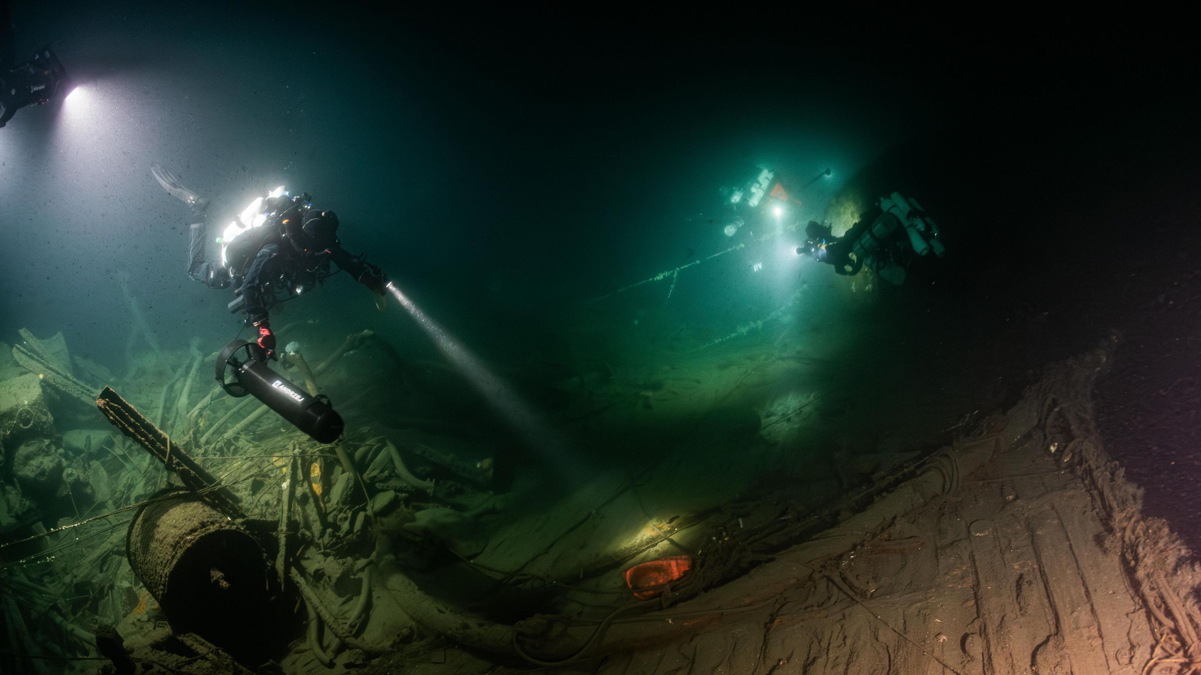 Divers explored the wreckage of HMS Nottingham with lights in the deep sea.