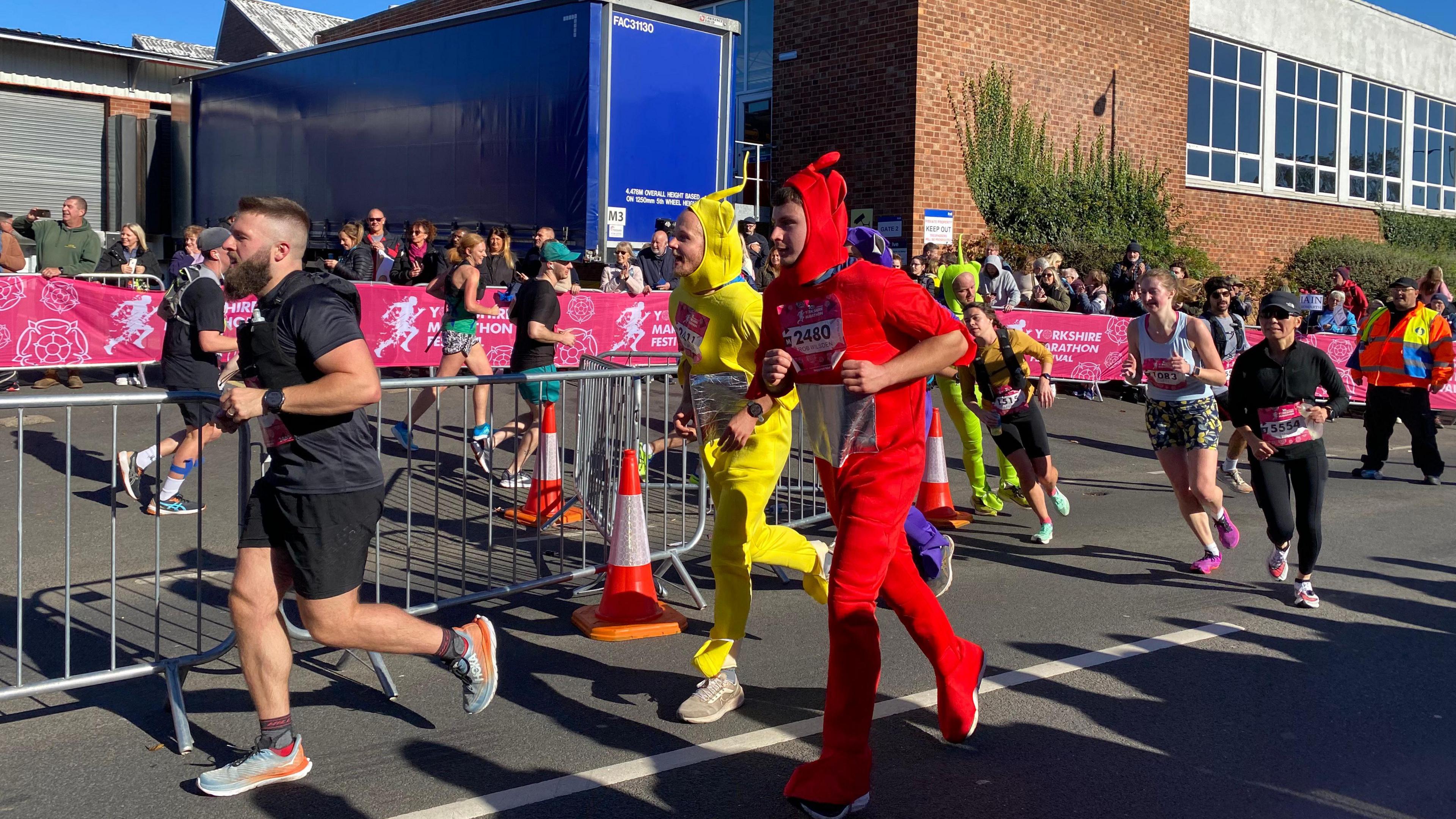 Two runners in Teletubby costumes - one red, one yellow - take part in the marathon
