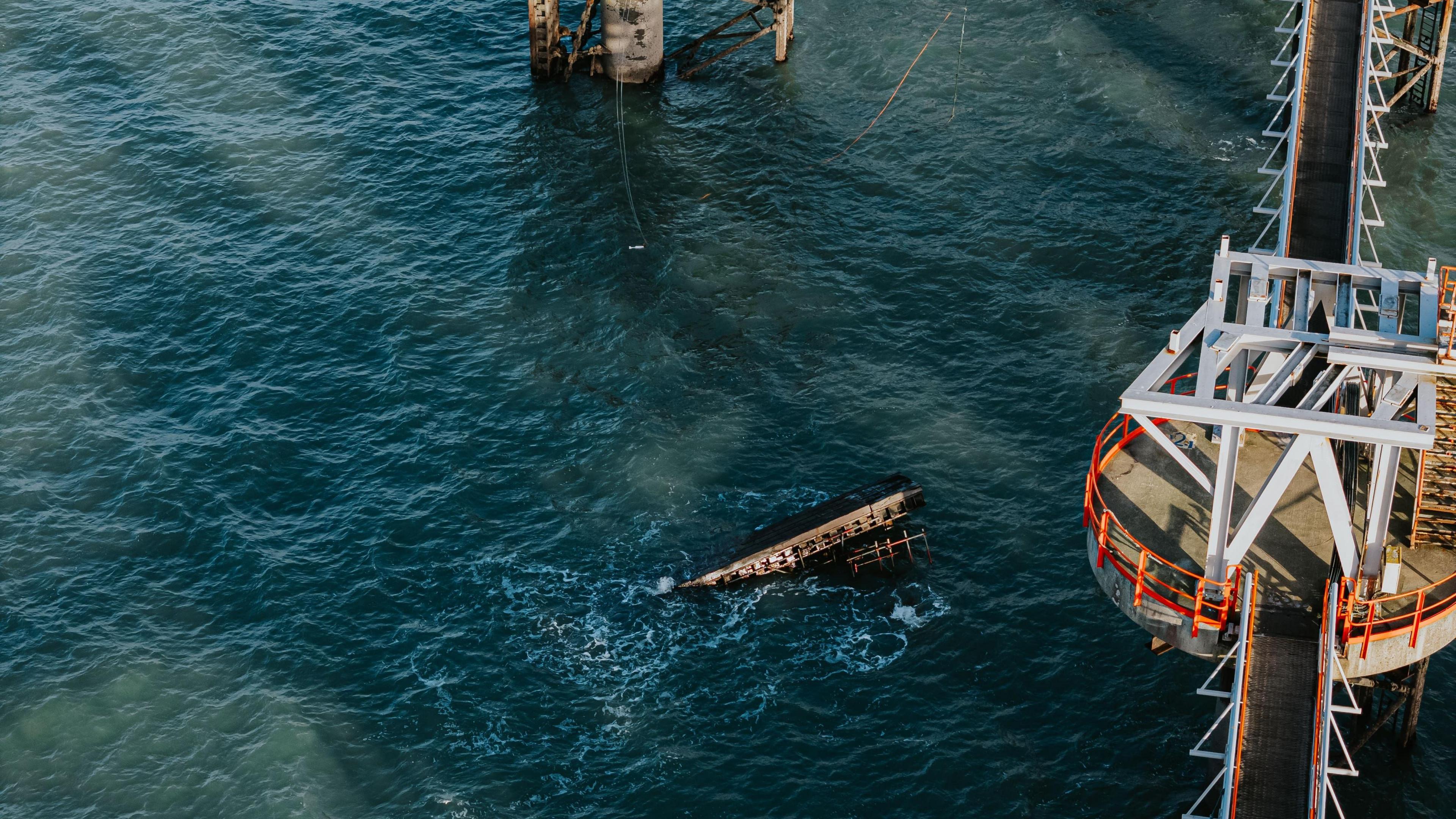 Metal object visible beneath the surface of the water. Industrial tower is visible on the right hand side.