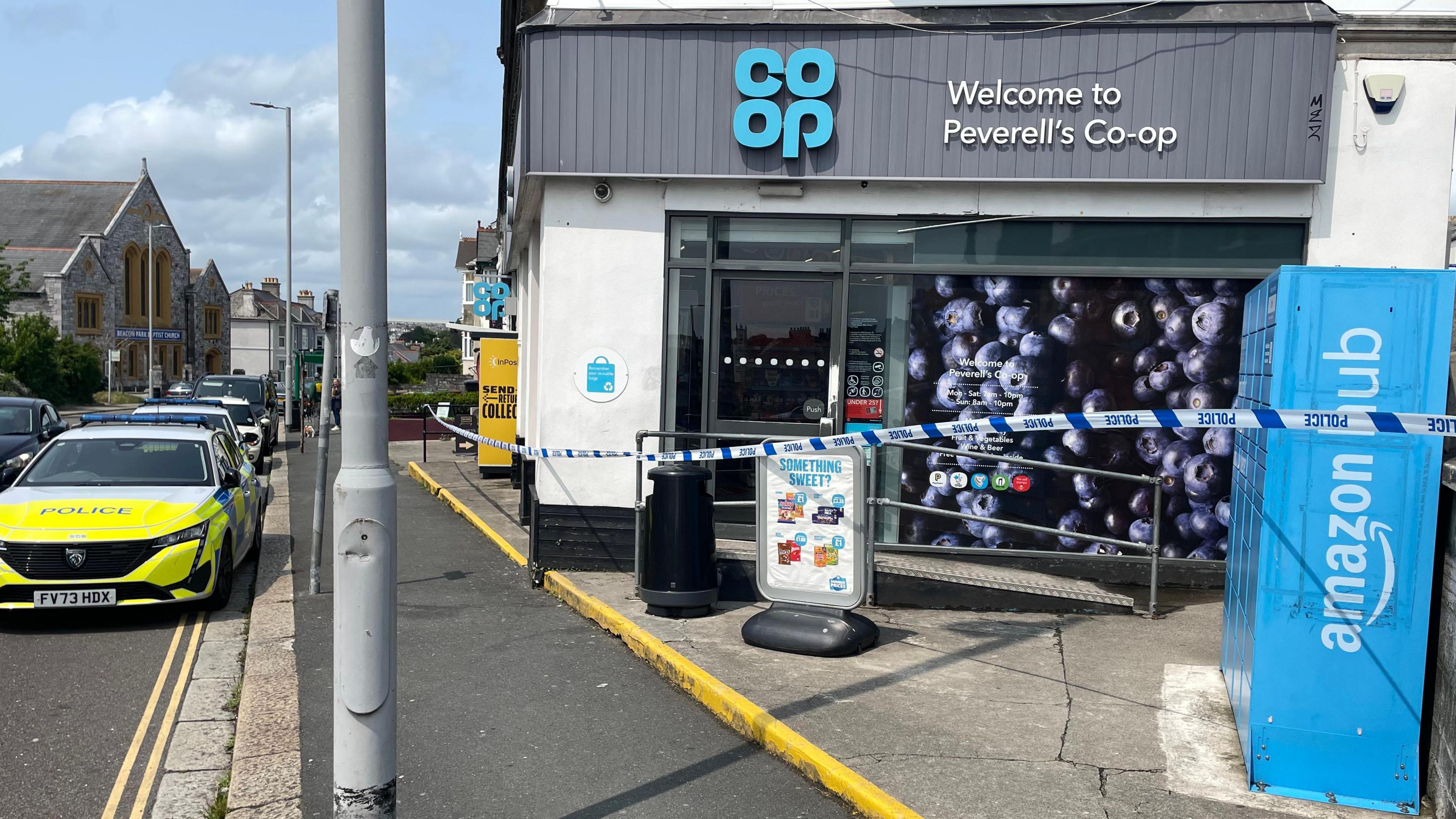Police vehicle and police tape outside the Peverell Co-op store.