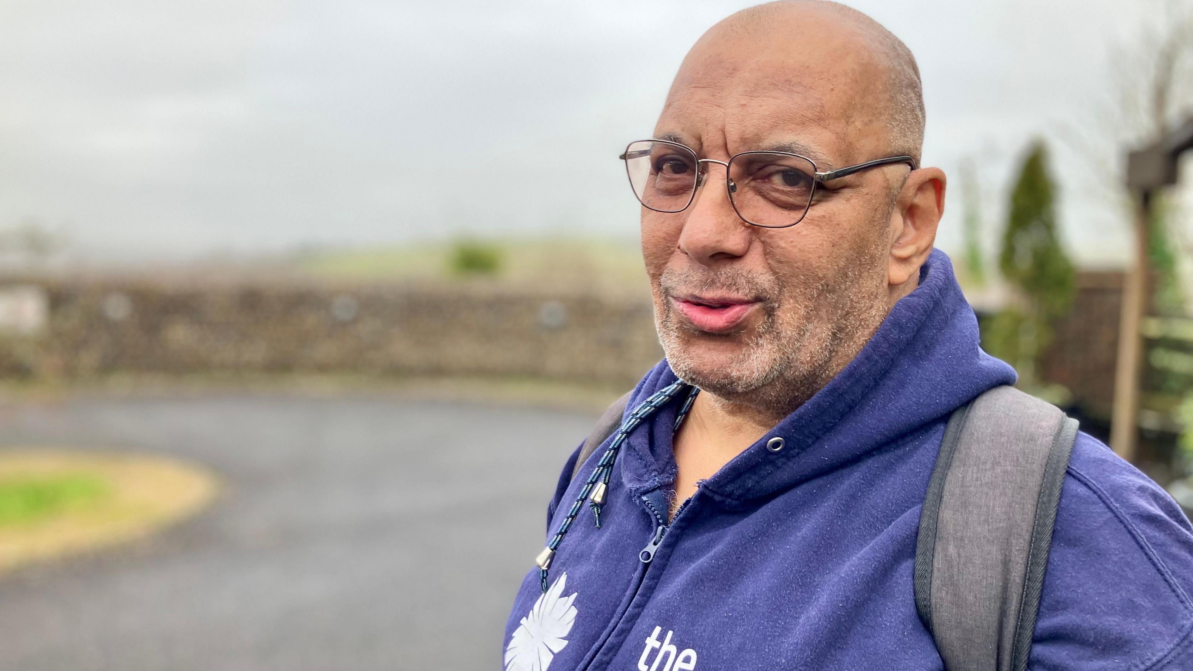 a man wearing a navy blue Sussex Beacon hoodie  