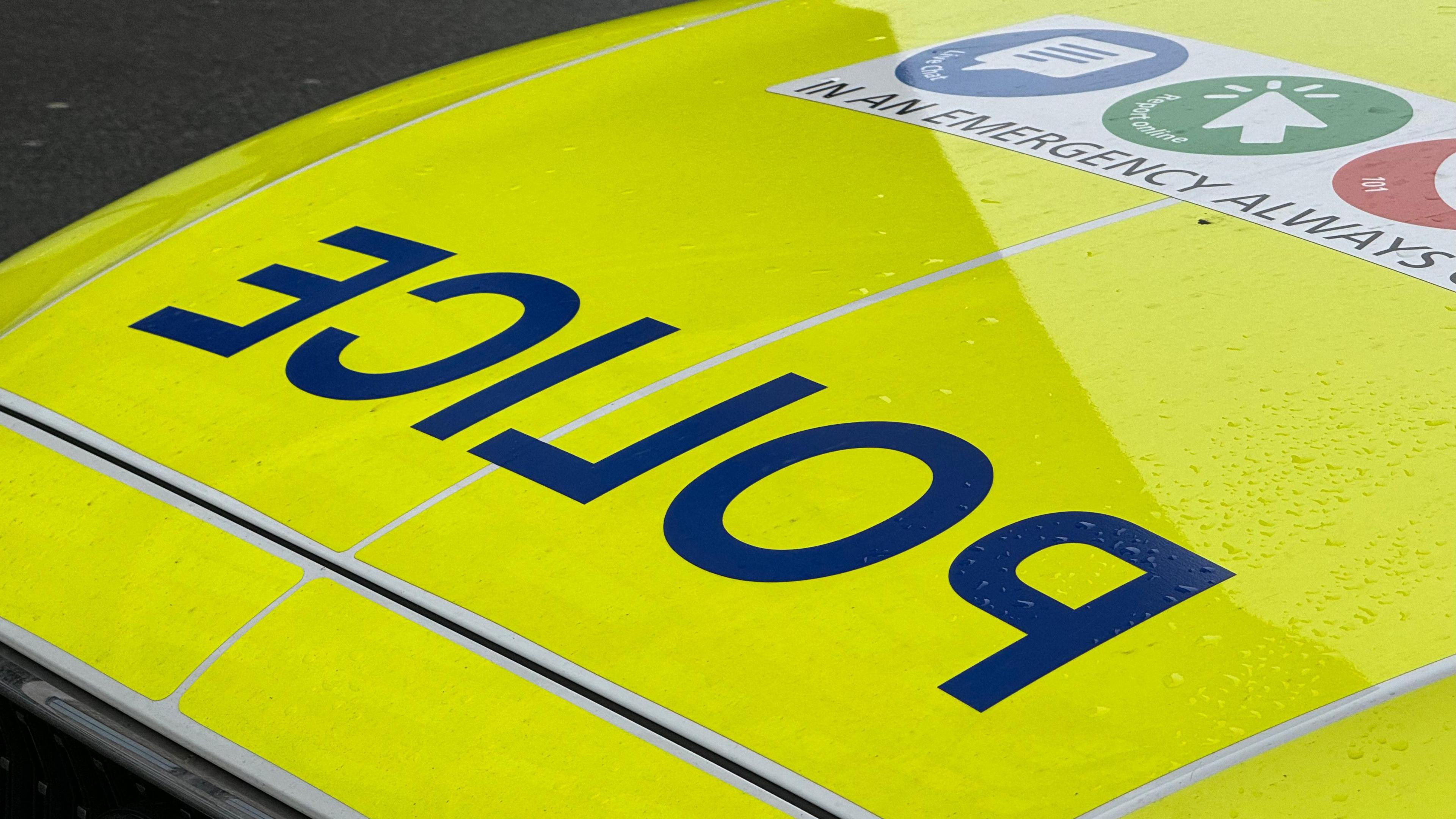 The bonnet of a police vehicle with the word police on it in reverse lettering.