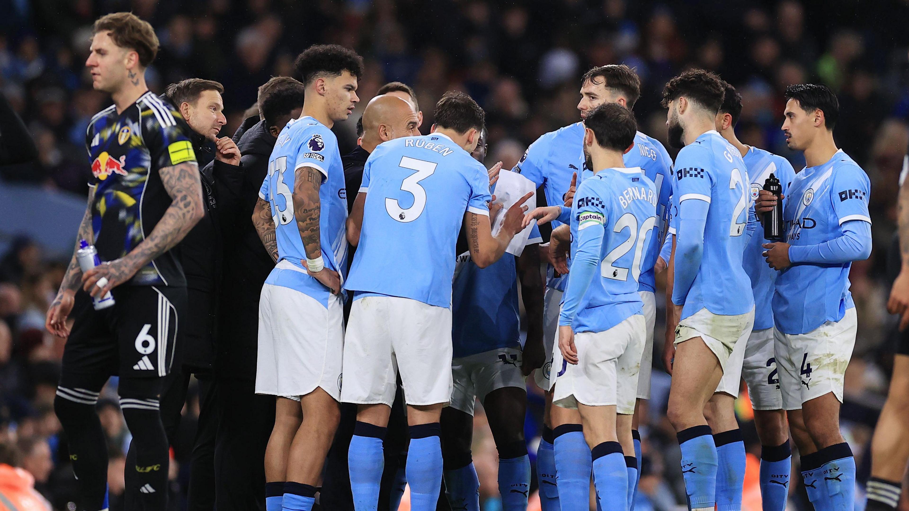 Pep Guardiola gathers his Man City players for a team talk