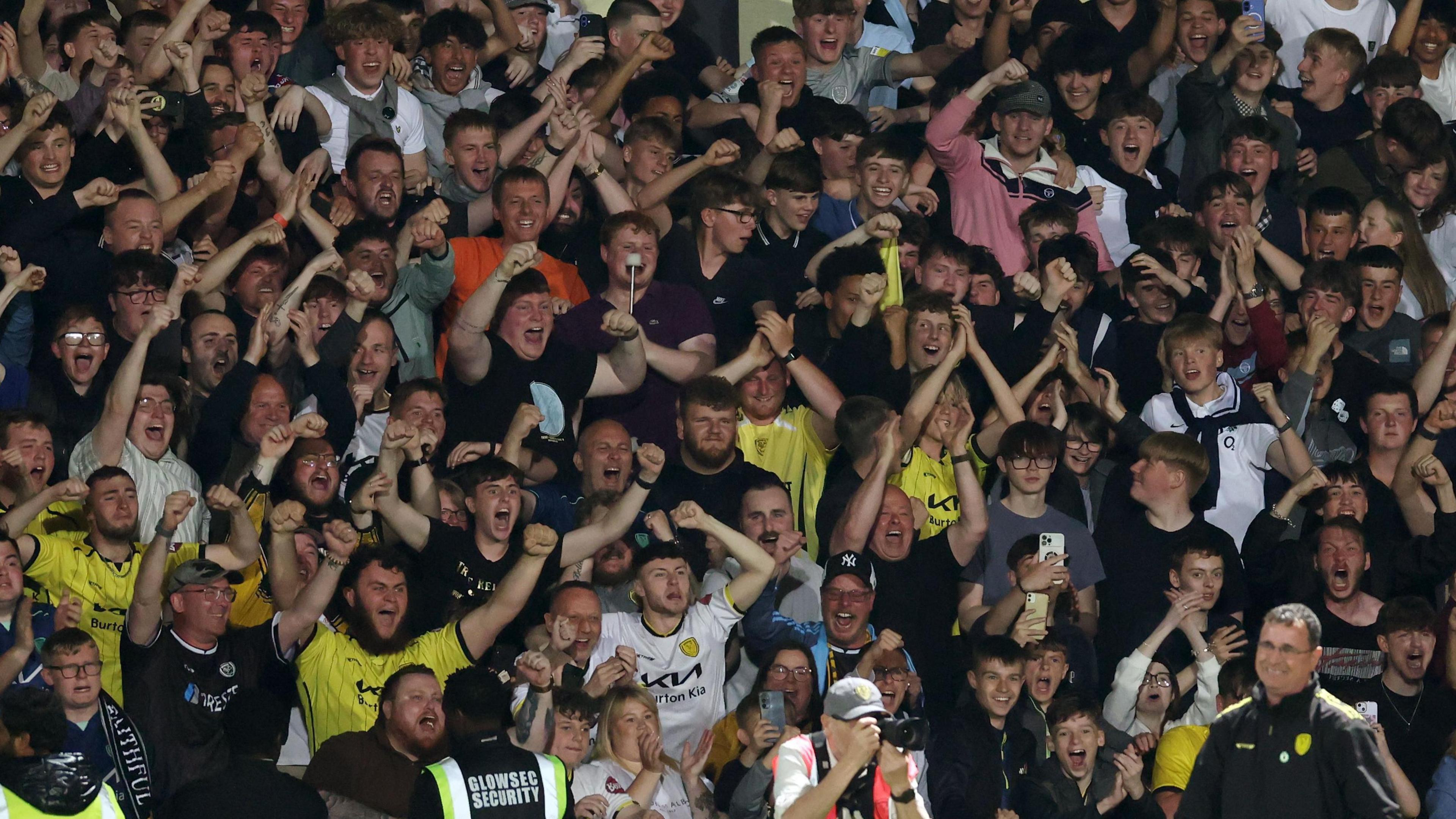 Burton Albion fans celebrate behind manager Gary Bowyer