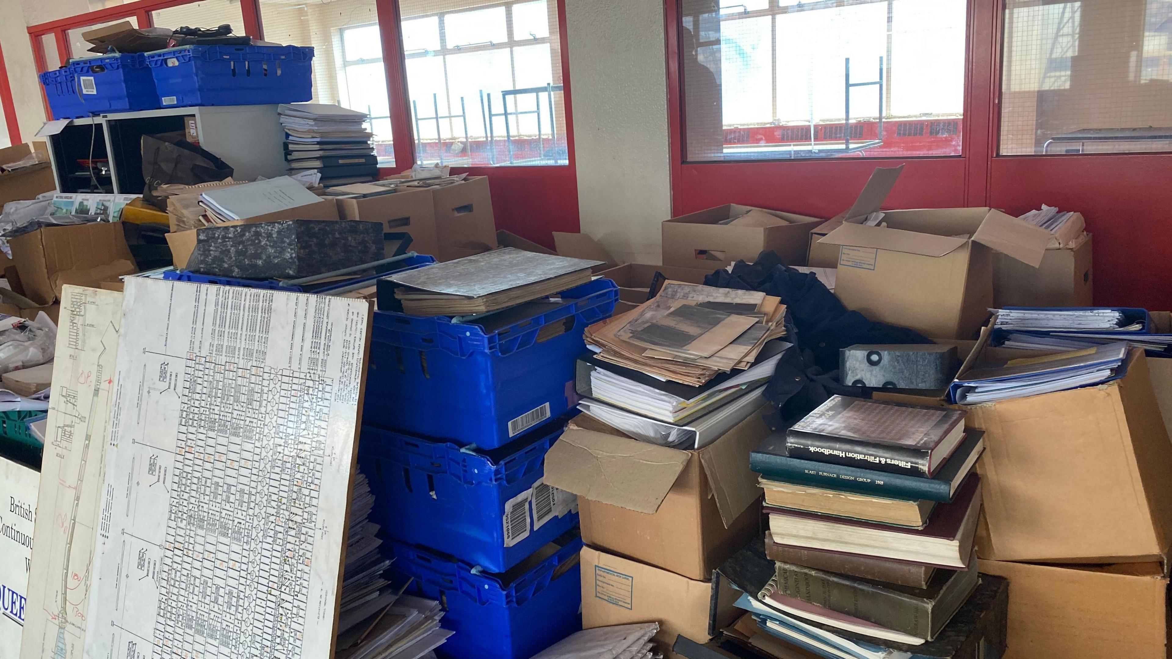 Piles of boxes, documents and newspapers documenting Teesside's steel heritage