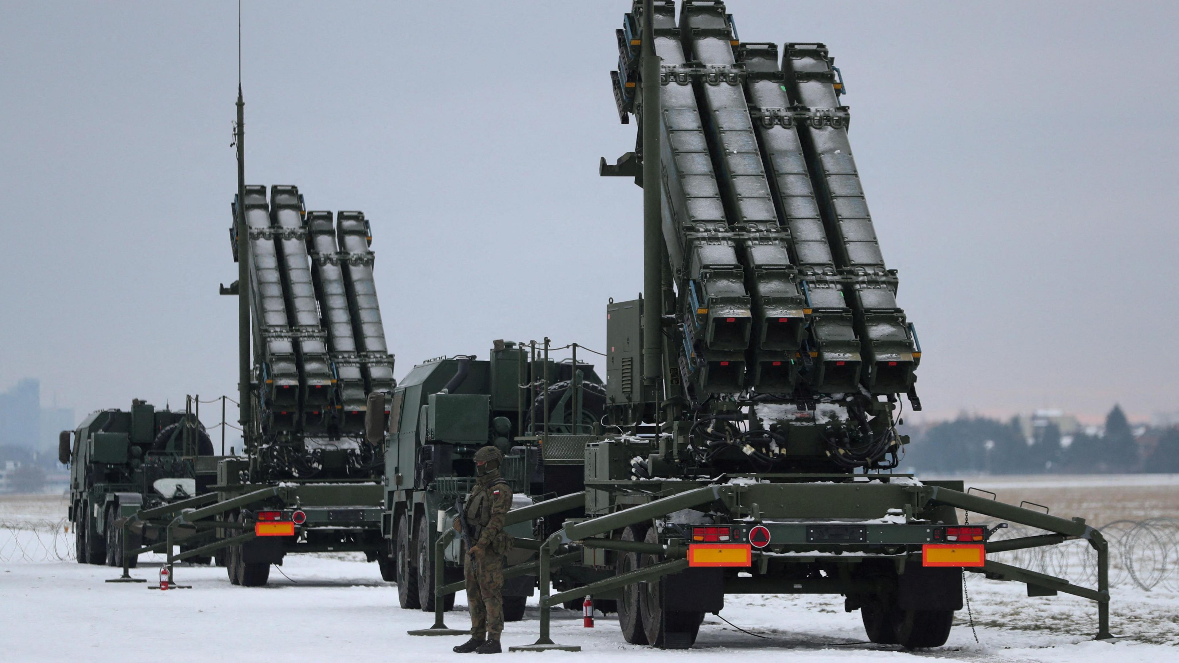 A serviceman patrols in front of the Patriot air defence system during Polish military training on the missile systems at the airport in Warsaw, Poland