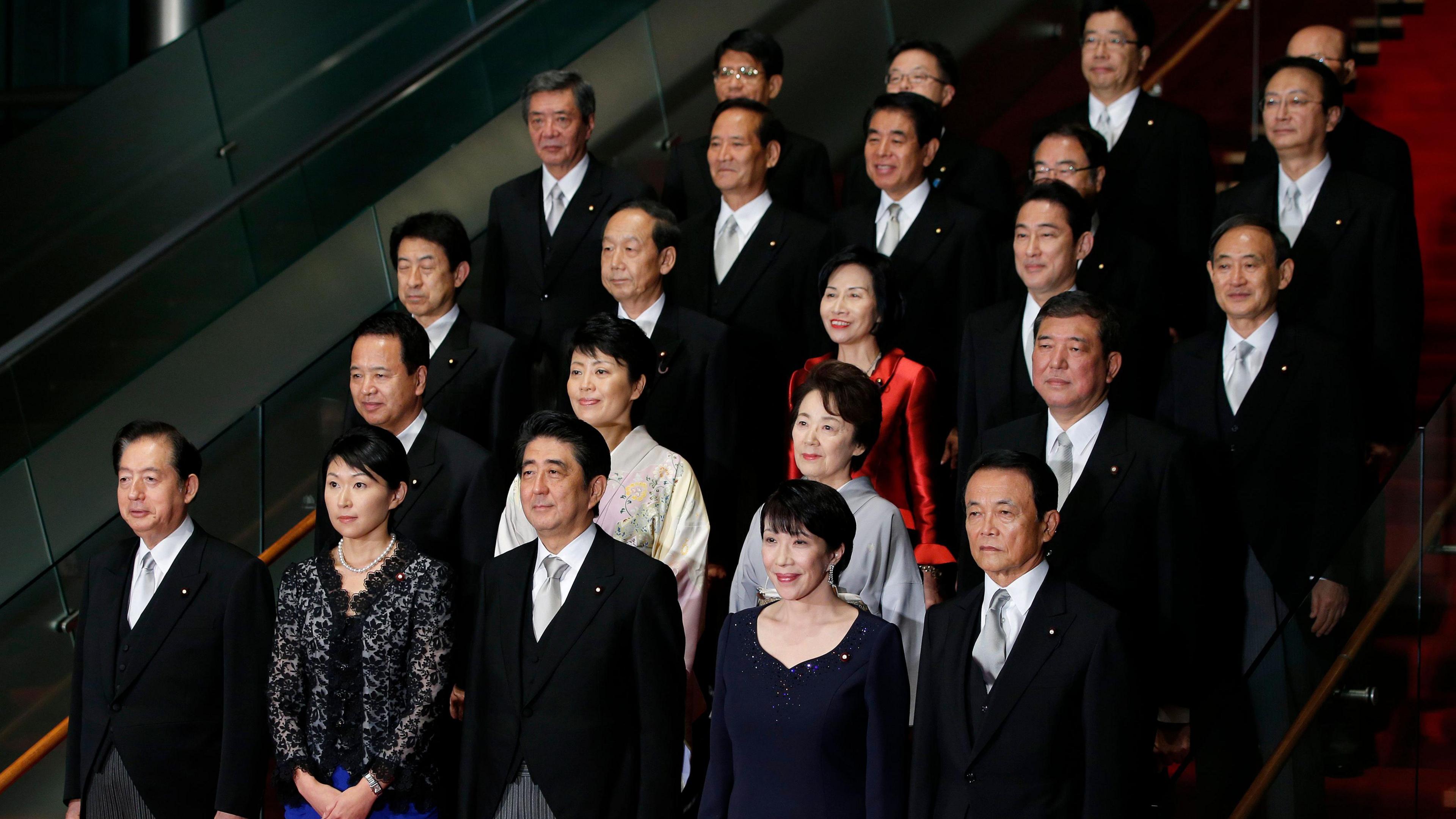 Shinzo Abe poses for a group photograph with members of his new cabinet at the prime minister's official residence in Tokyo