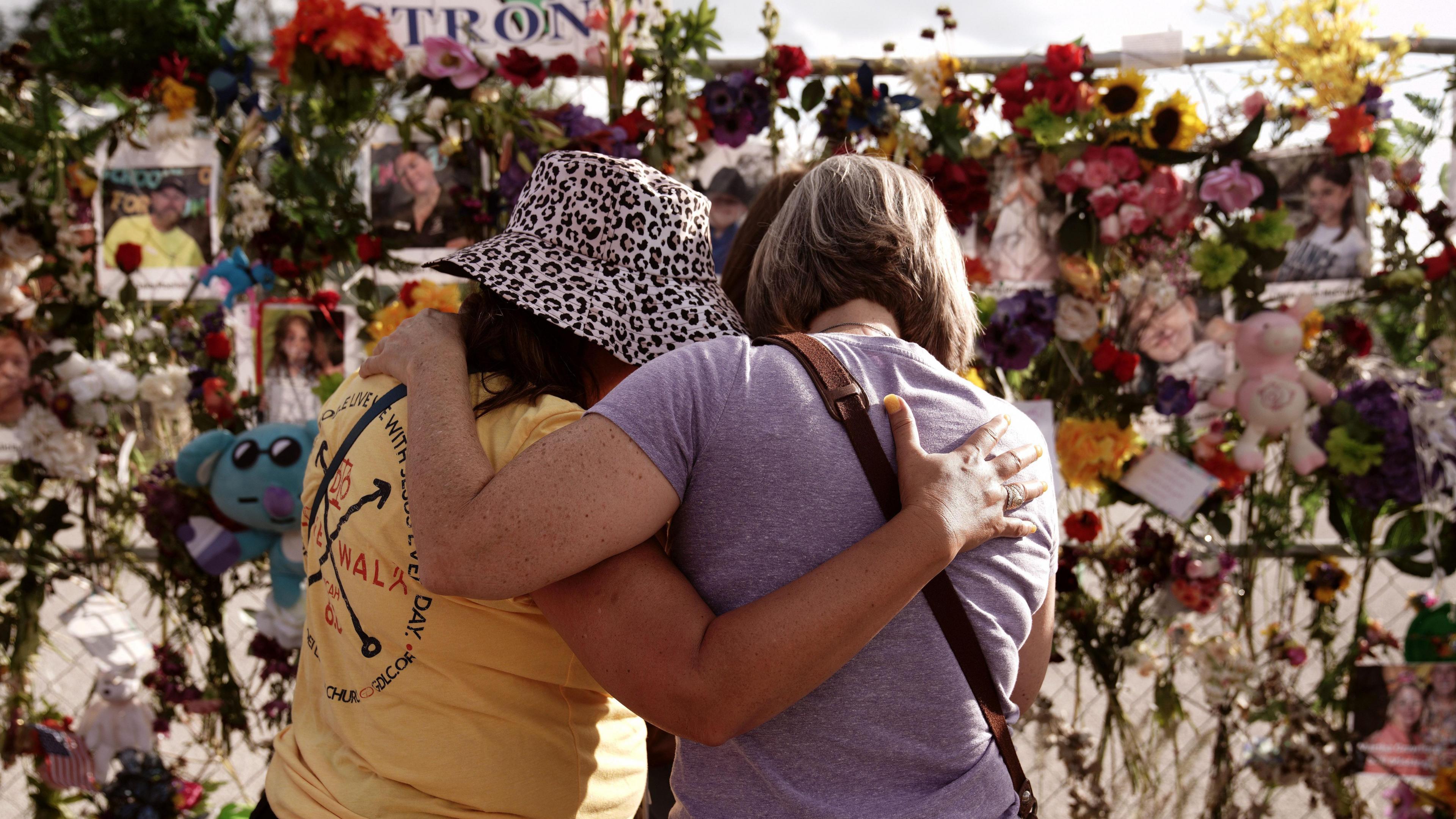 Two women mourn at a memorial for the victims of the Texas floods