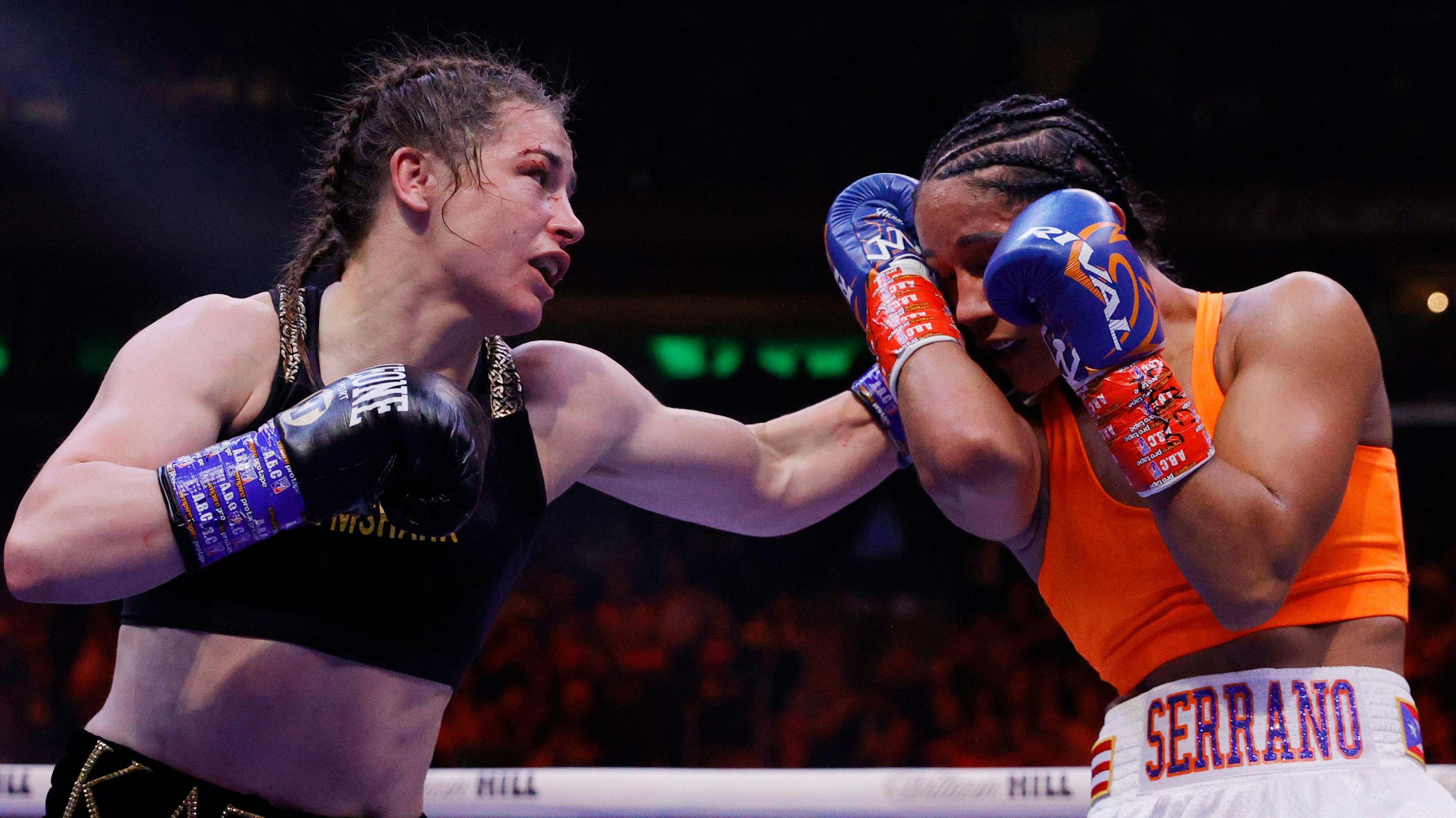 Katie Taylor lands a punch on Amanda Serrano during their fight in 2022