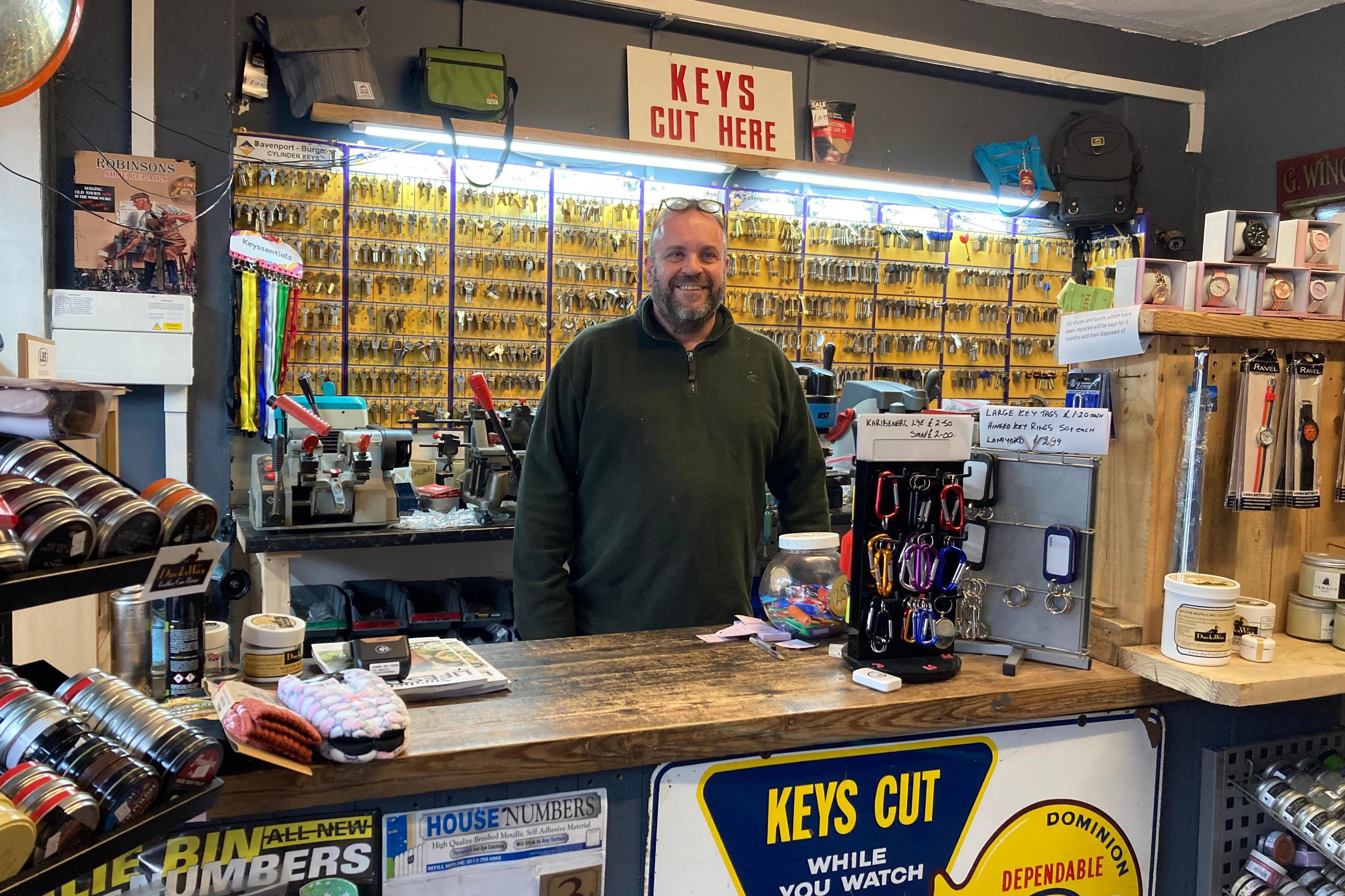 Scott Robinson stood behind the counter of his business, Robinson's Shoe Repairs