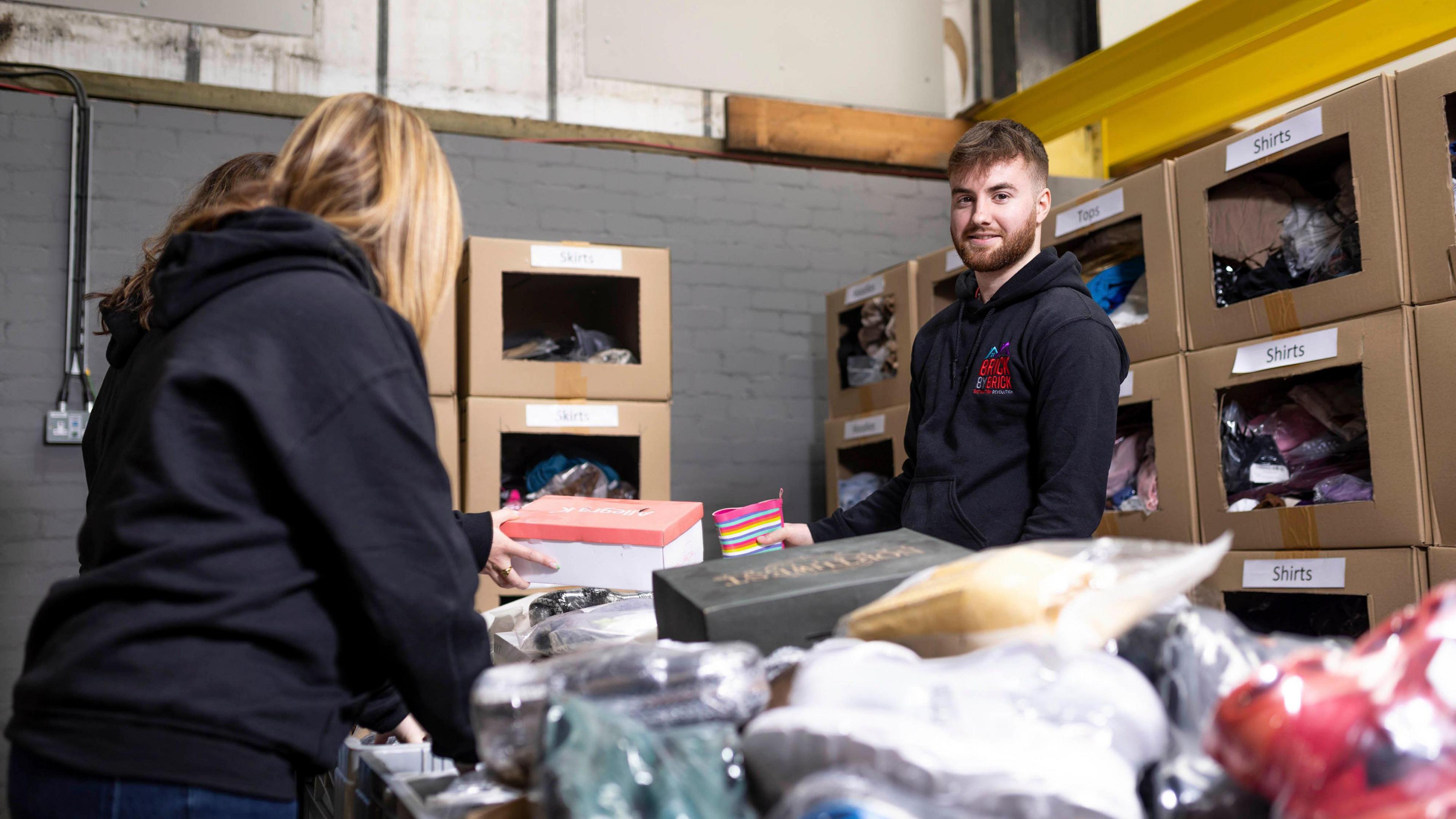 Two workers separating household donated goods in a warehouse