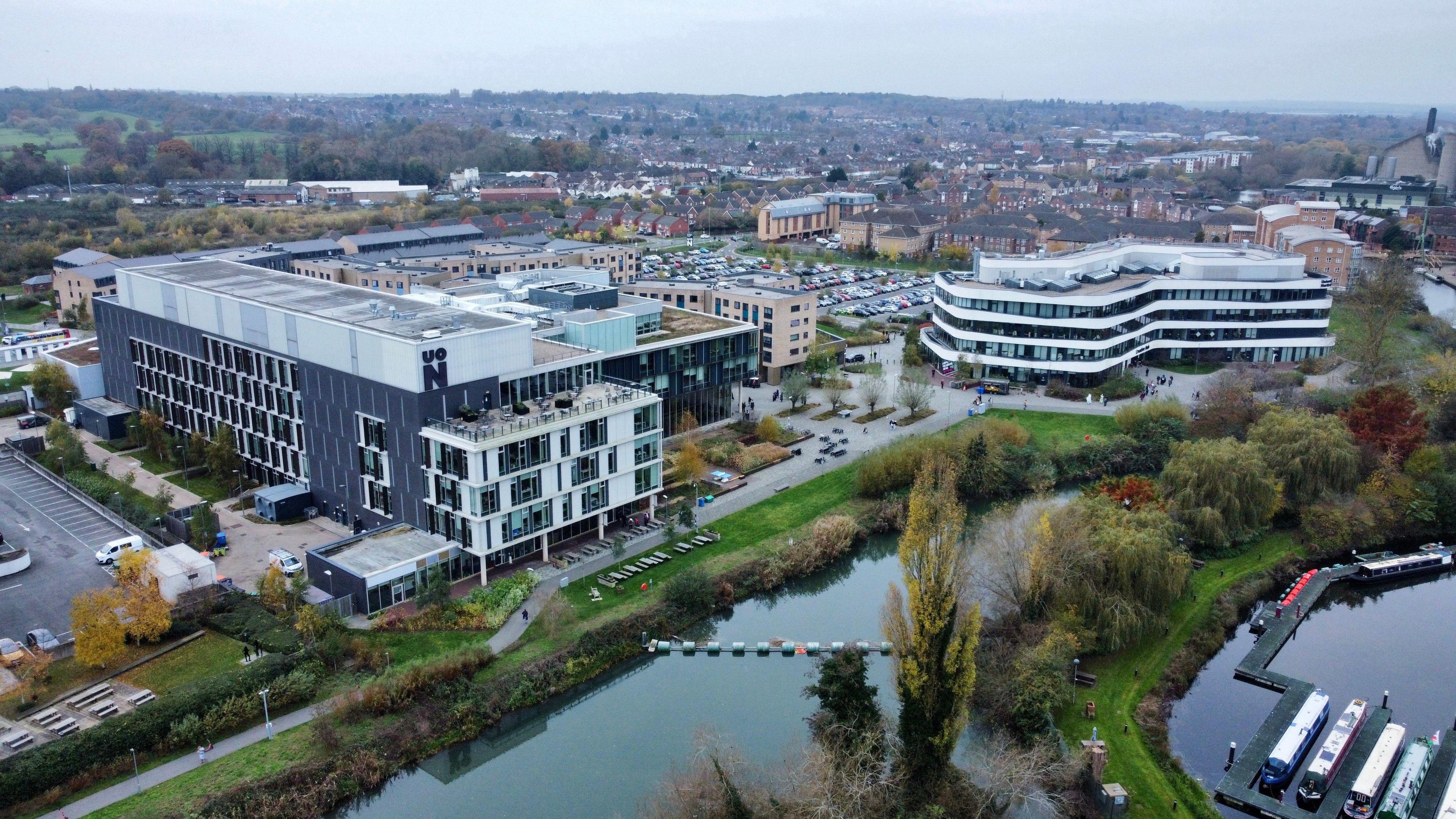 An aerial photo of the university - two large glass buildings next to a river.