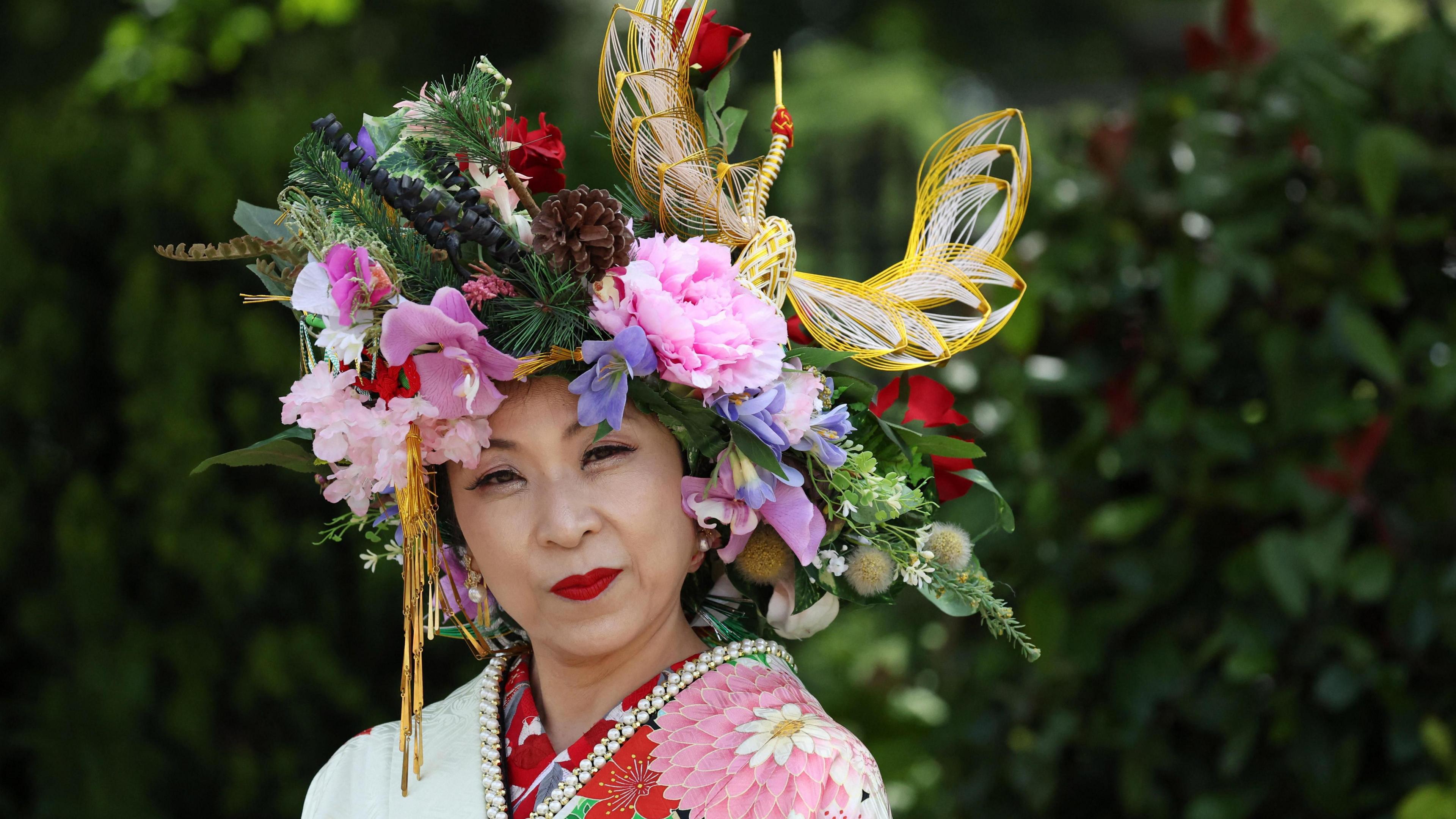 An Asian woman wears an ornate floral headdress at Royal Ascot