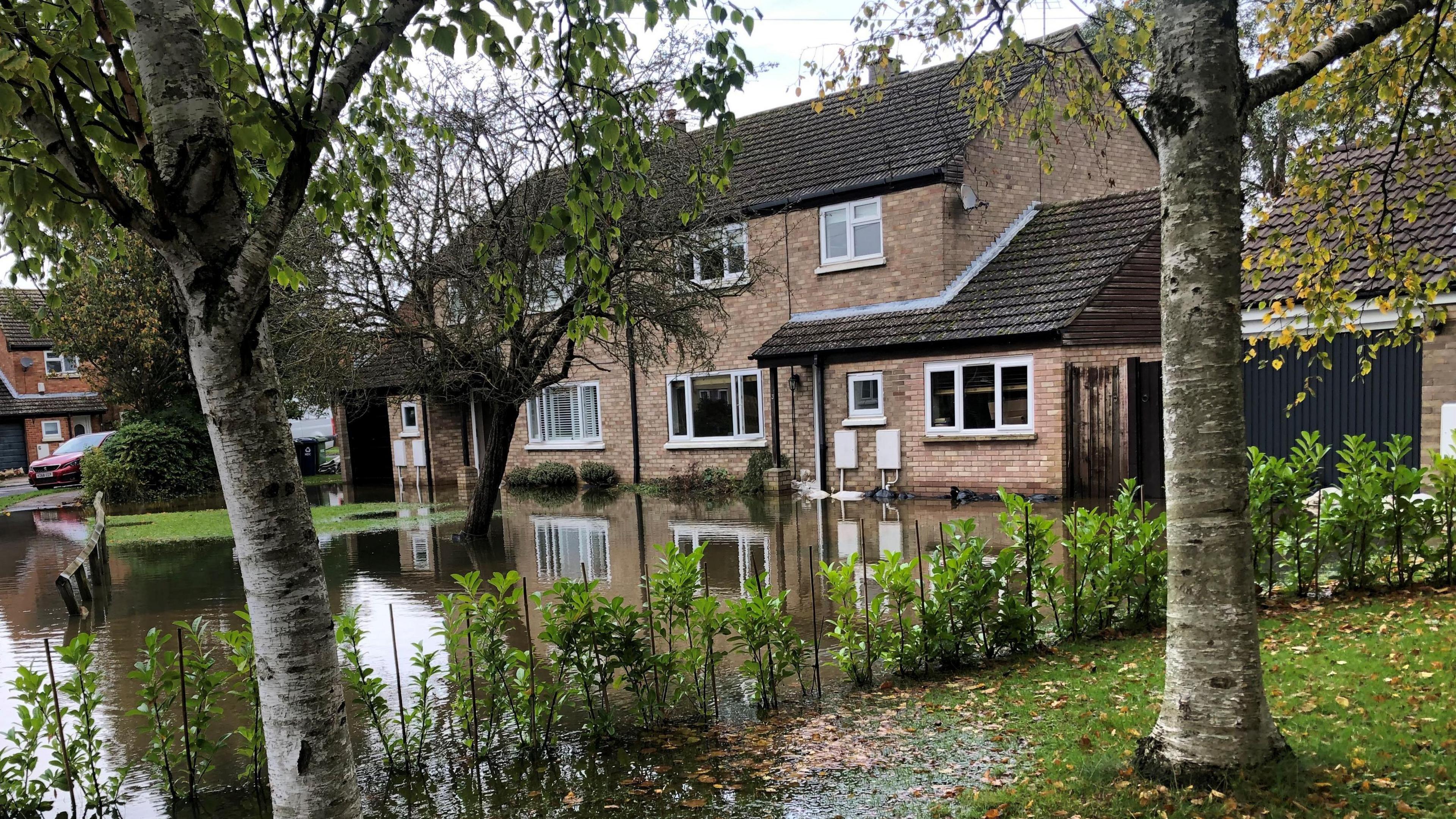 Two semi-detached houses on Hansell Road, Brampton, with water lapping their front doors. The house on the left was breached and the home was evacuated. The right hand one did not have water in because the resident said it was "half a brick higher".