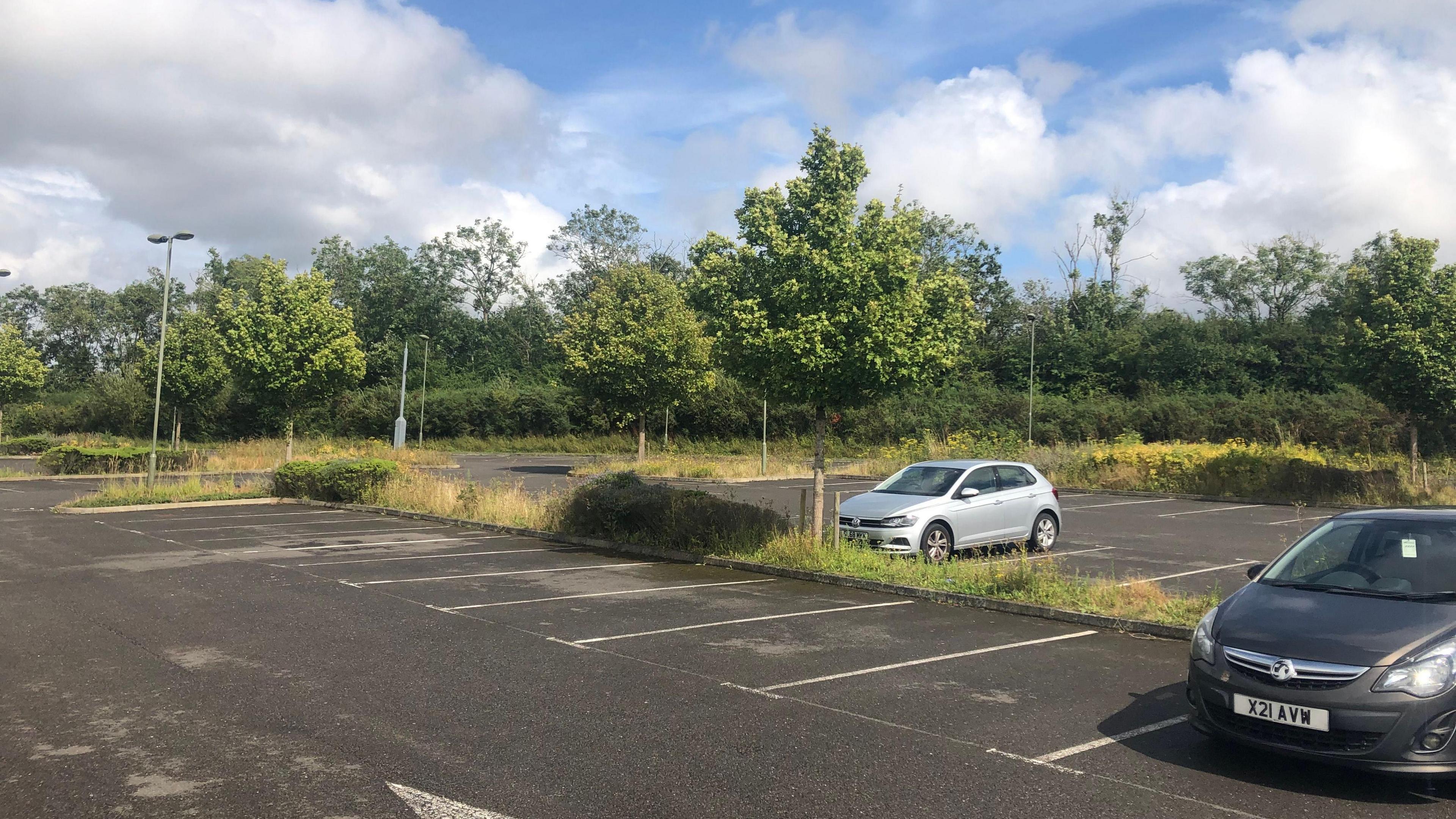 A nearly empty parking zone with two cars in it. 