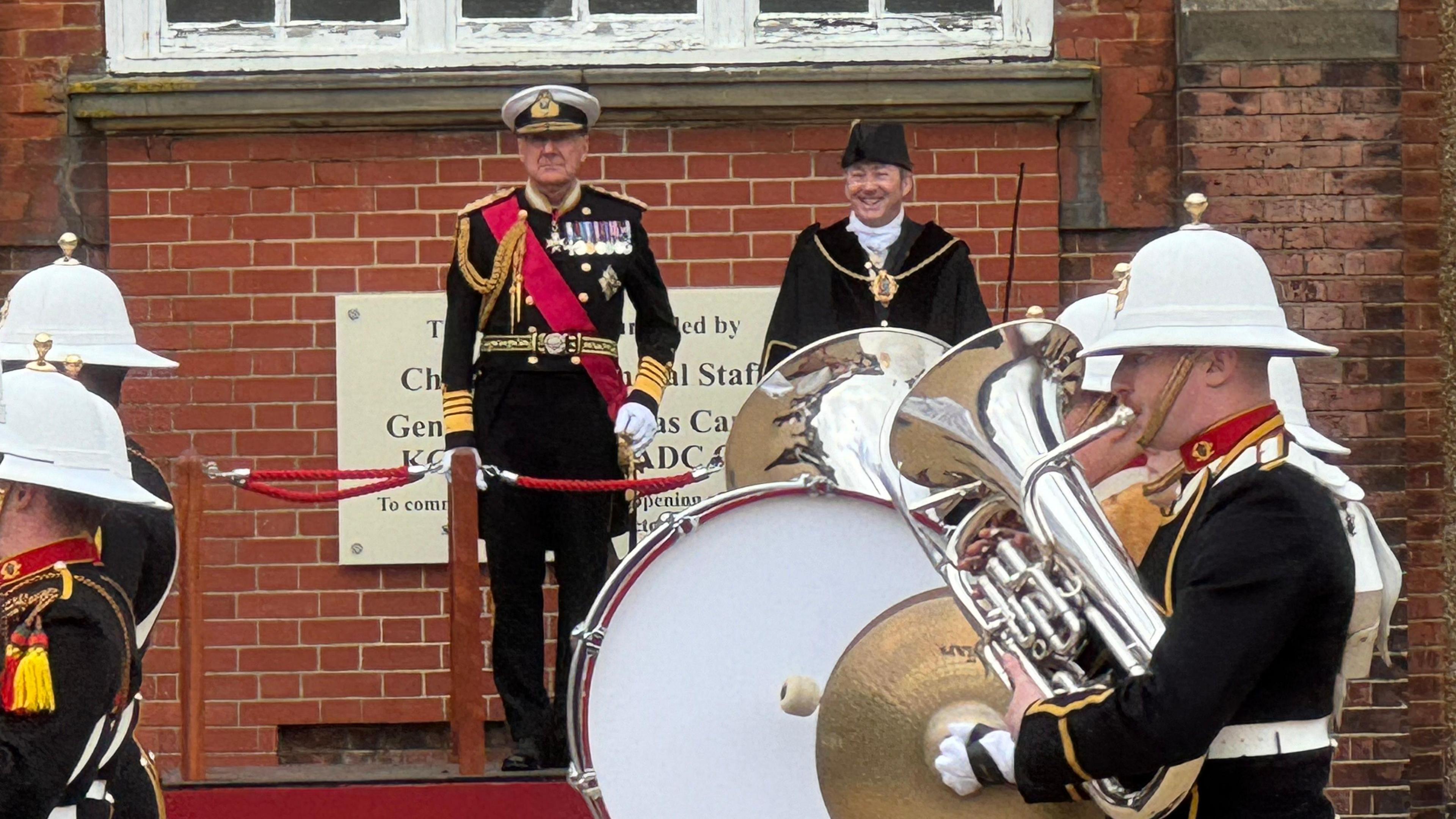 Admiral Sir George Zambellas in full ceremonial uniform at his appointment ceremony for Lord Warden of the Cinque Ports in Dover, as the band of the Royal Marines marches past.