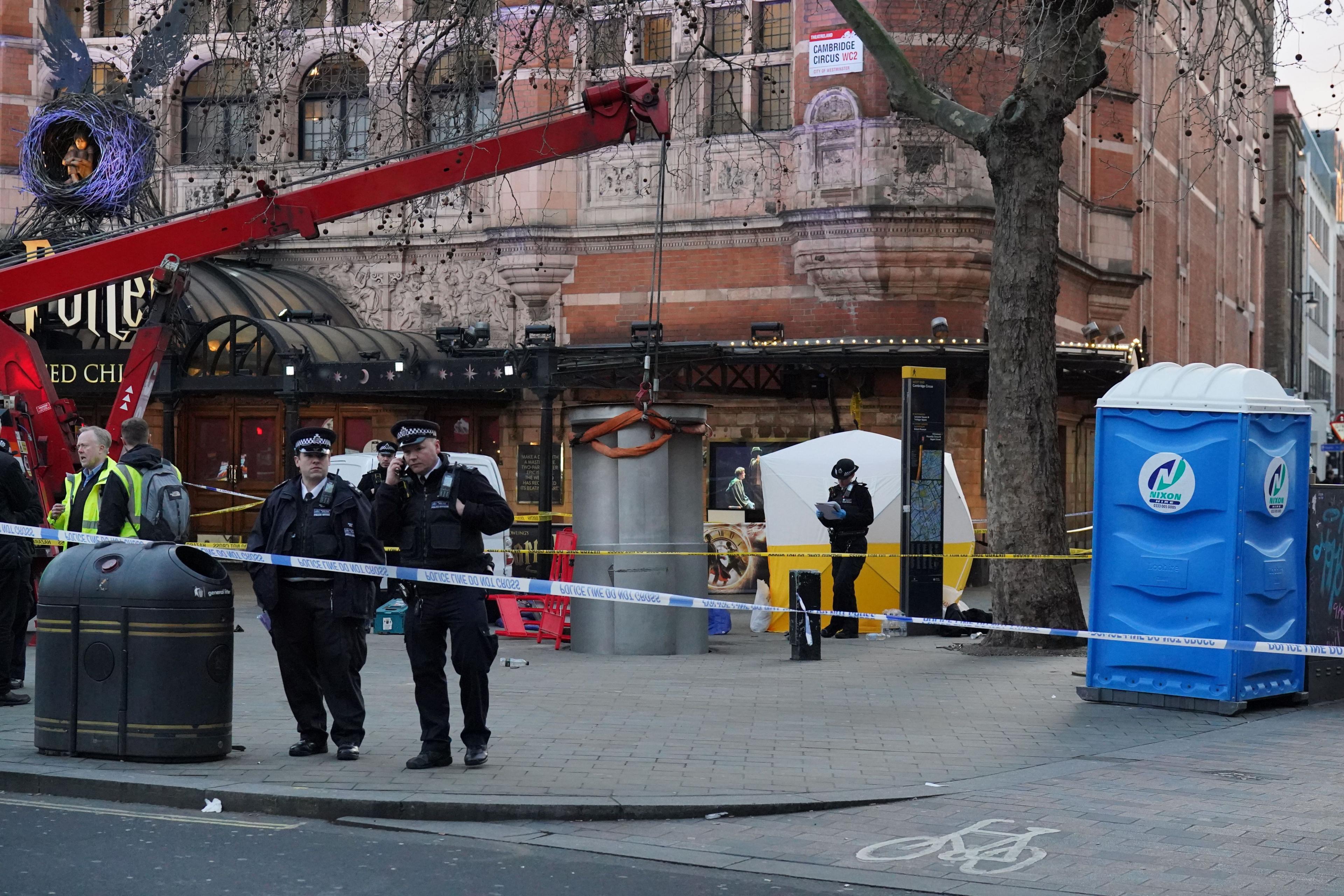 A police tent is erected behind a pop-up urinal being held by a crane at Cambridge Circus on the junction between Shaftesbury Avenue and Charing Cross Road 