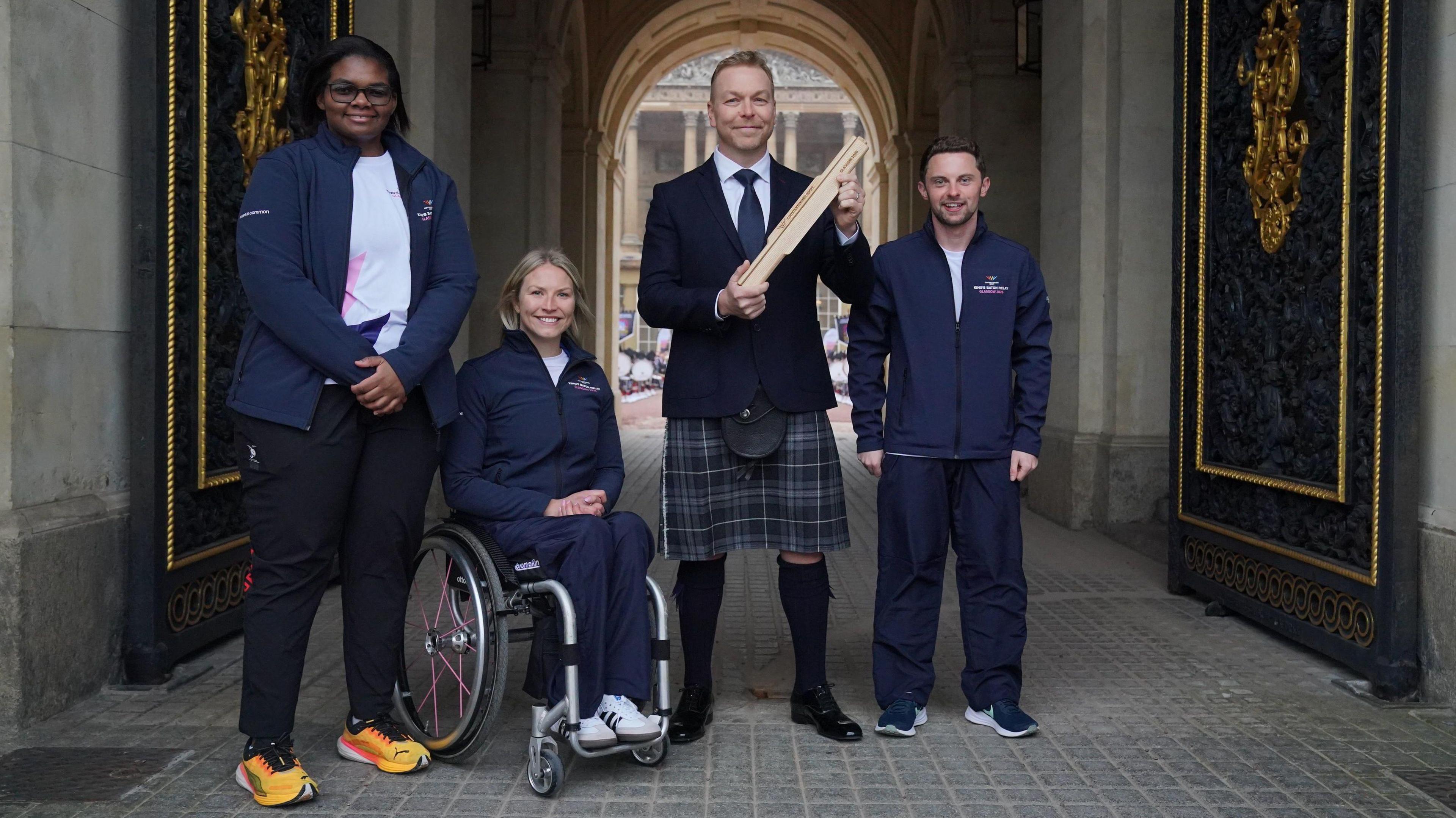 Sir Chris Hoy with the next three baton bearers who are wearing commonwealth games tracksuits