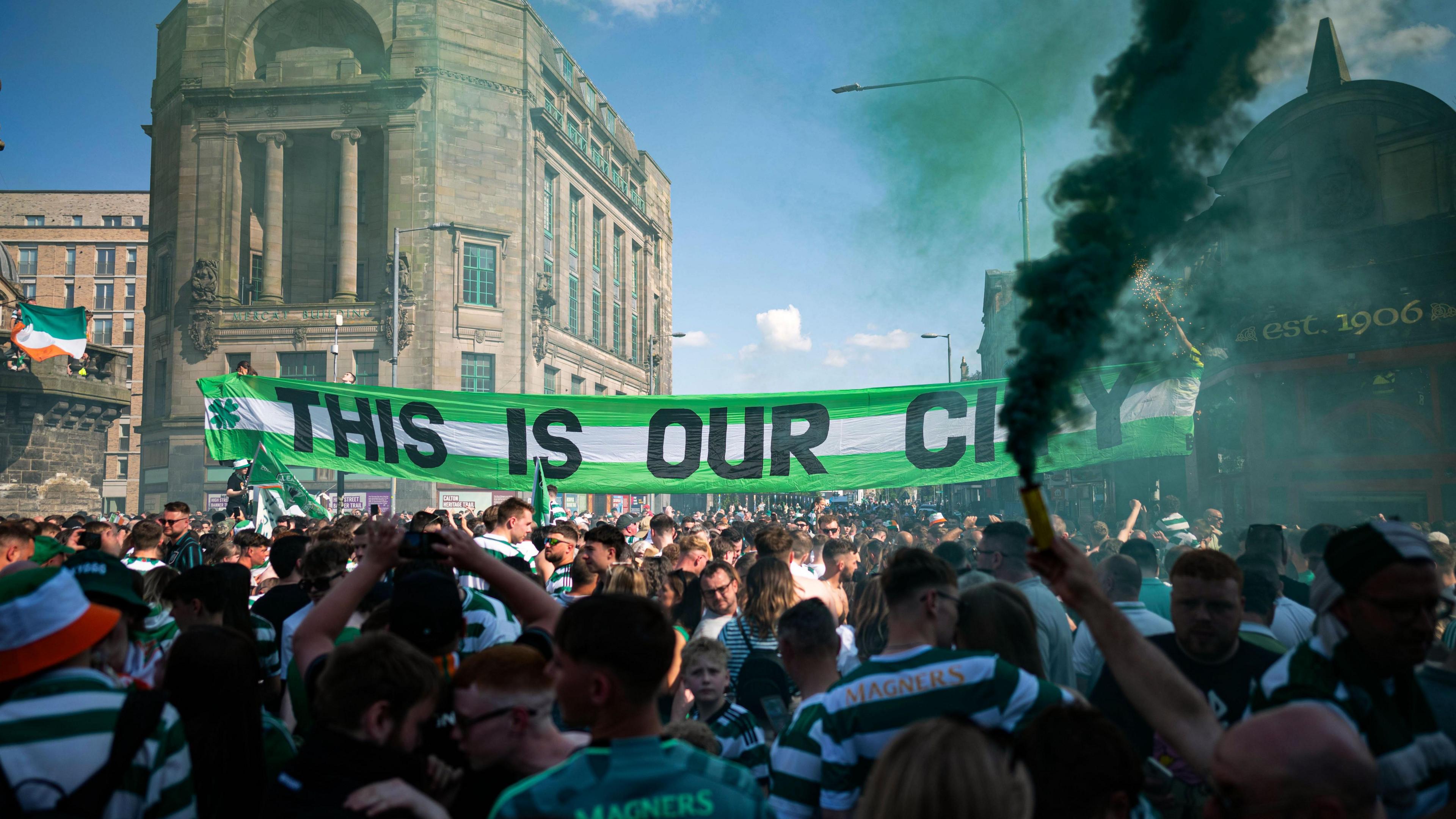 Celtic fans holding a banner reading 'This is our city'.