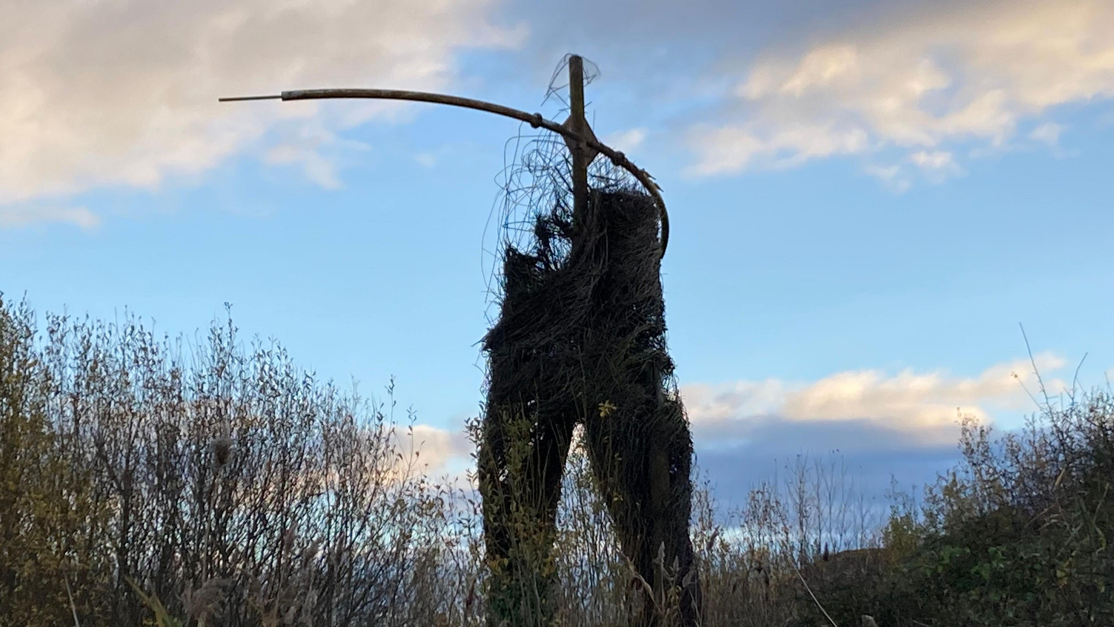 Massive sculpture of willow in the shape of a man. It's looking quite broken now with no head and lots of sticks.