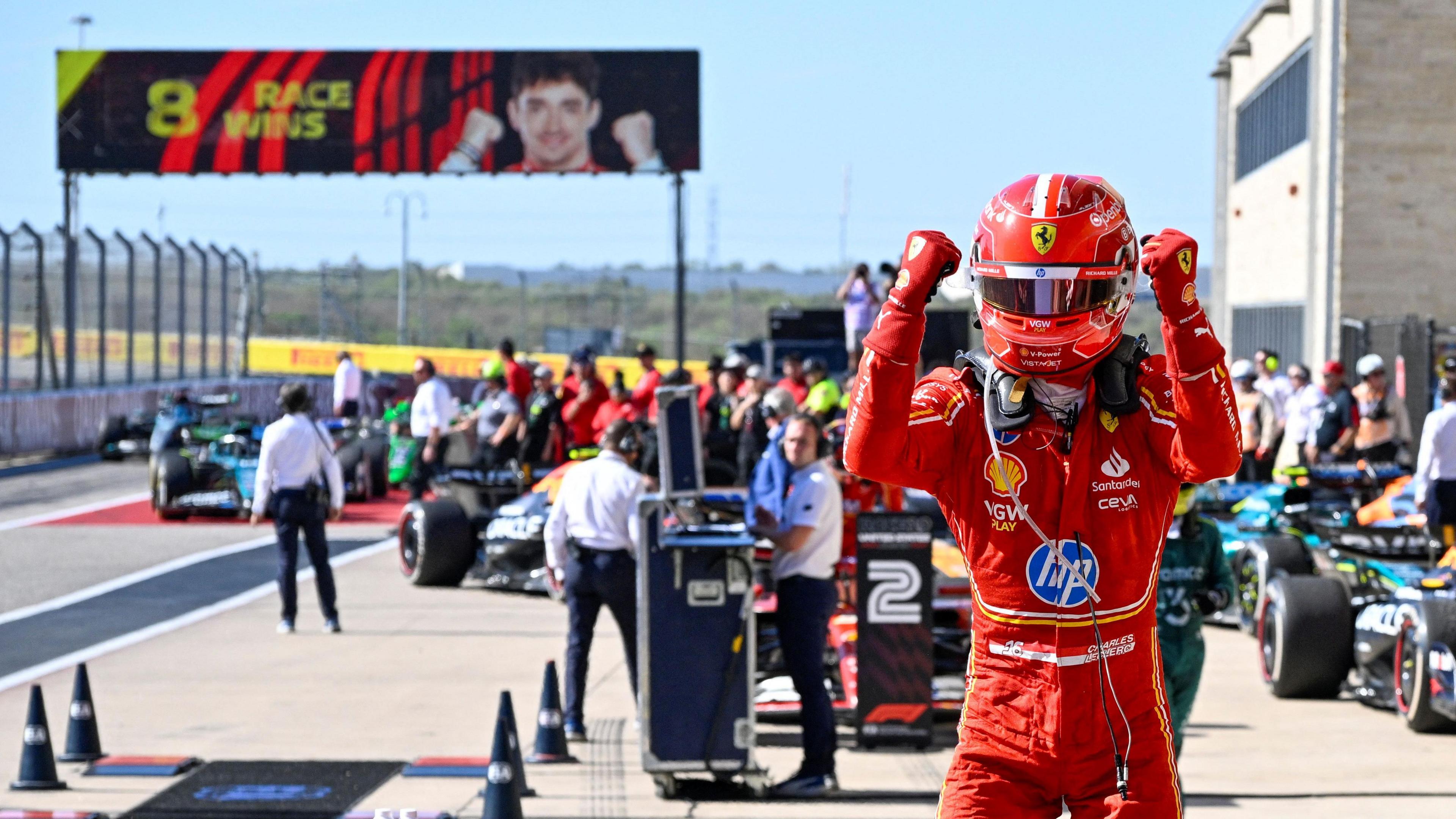 Charles Leclerc clenches his fists in celebration as he climbs out of his Ferrari after winning the United States Grand Prix