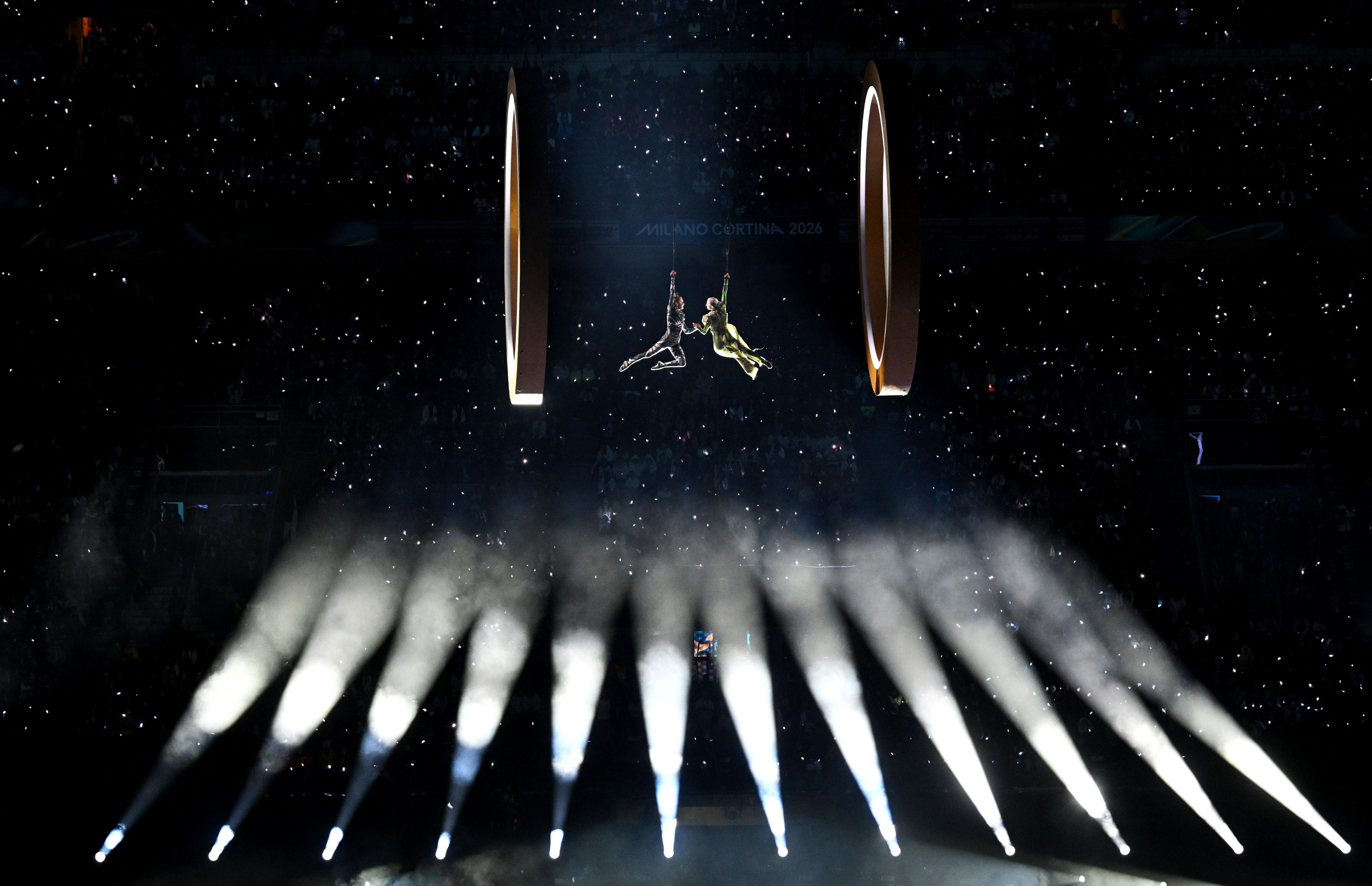Two aerial actors are suspended in the San Siro during the opening ceremony