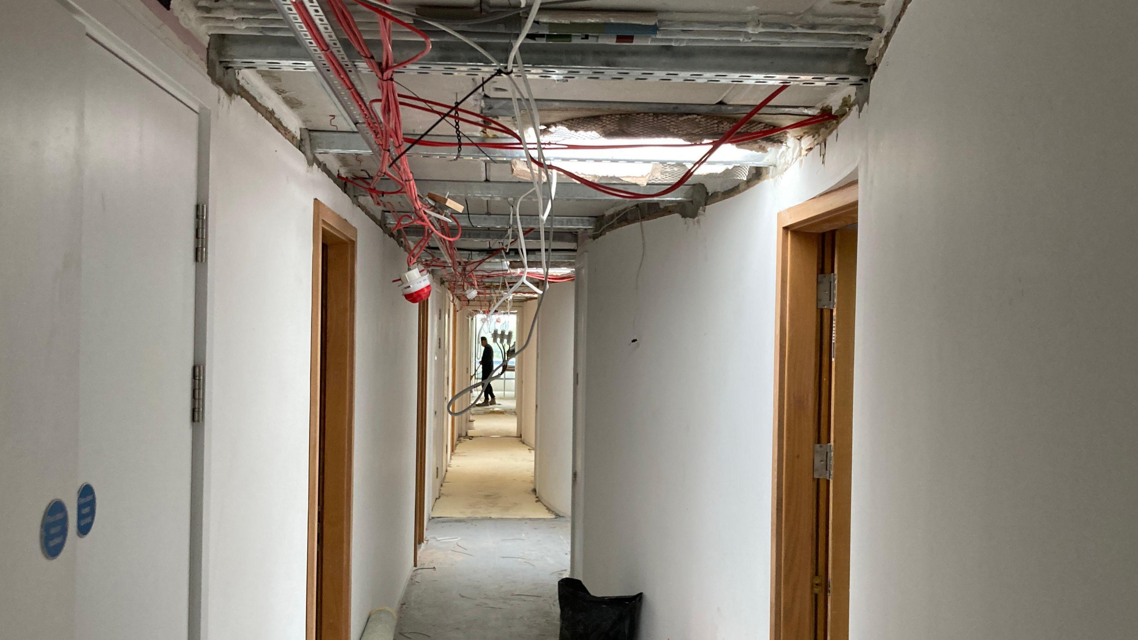 Wires hanging from ceilings along a corridor in a university accommodation block