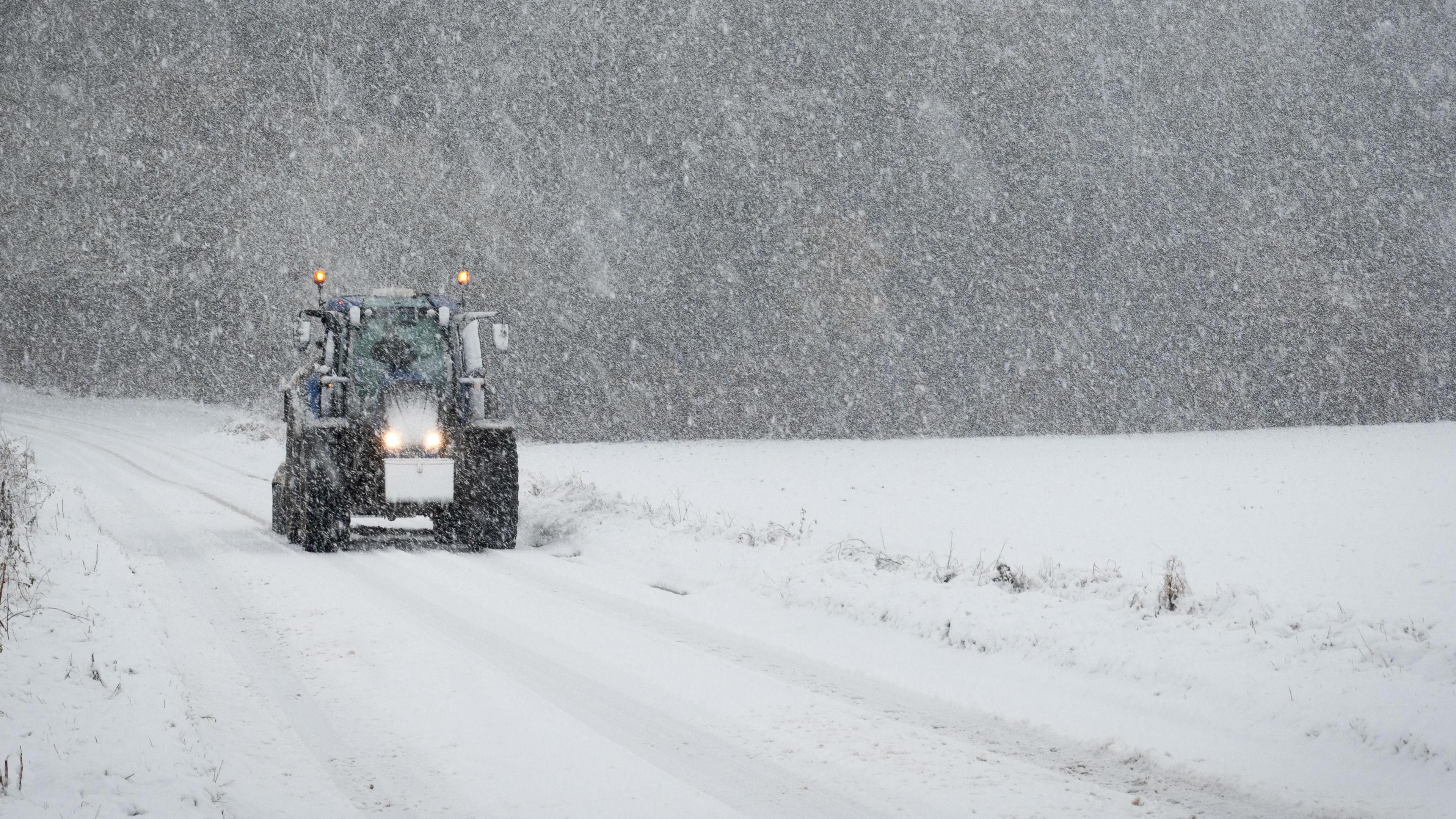 A tractor manoeuvres through heavy snowfall in the village of Meikleour, in Perth and Kinross