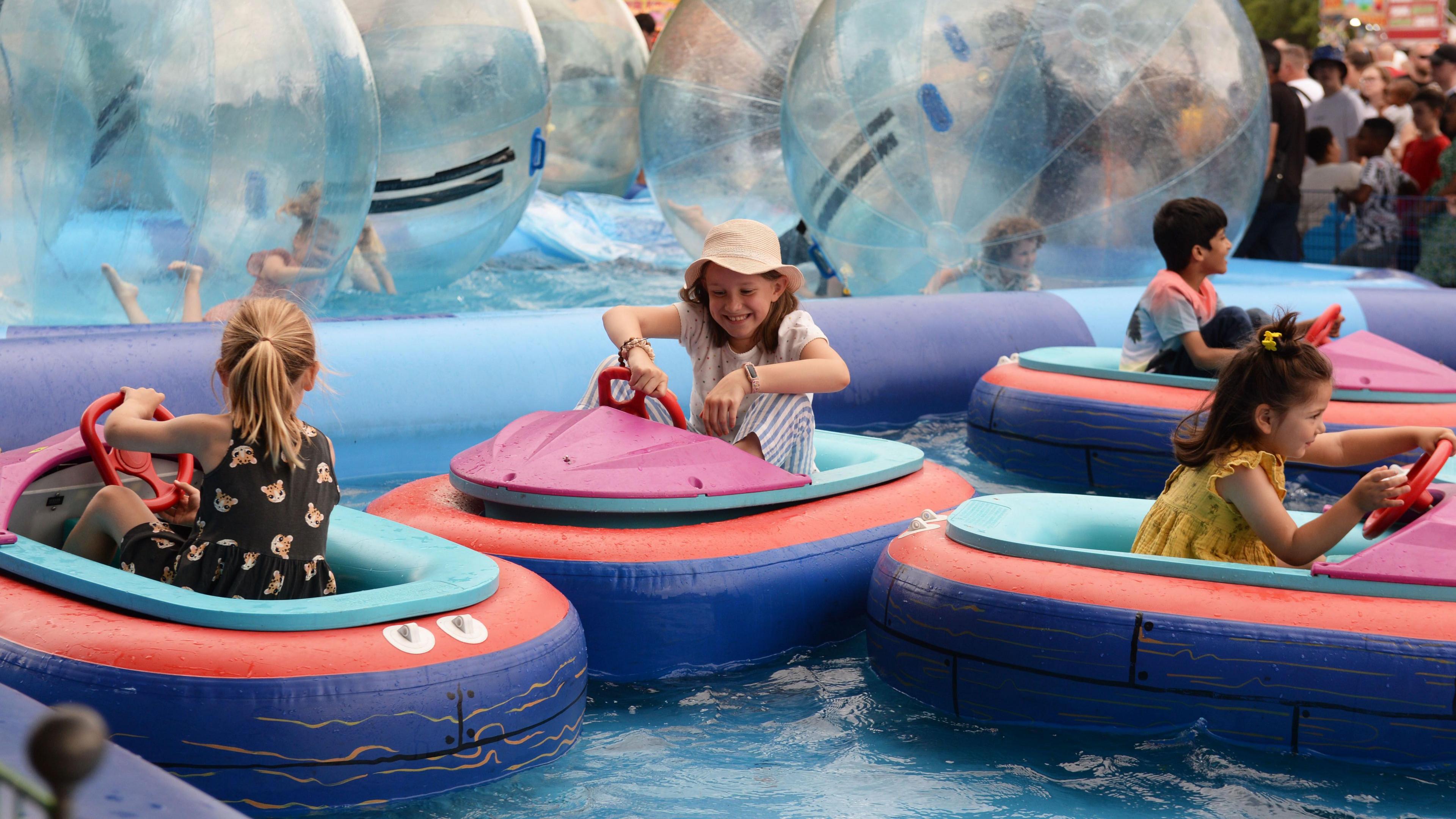 Four children playing in aqua boats at Bedford River Festival