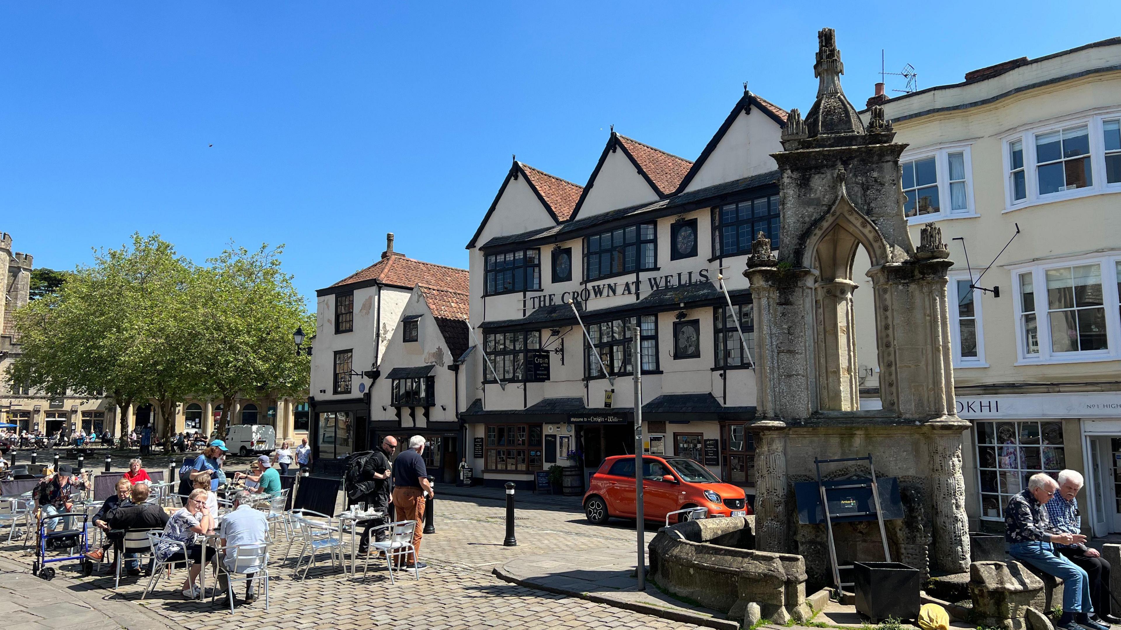 Wells in Somerset showing old buildings and people