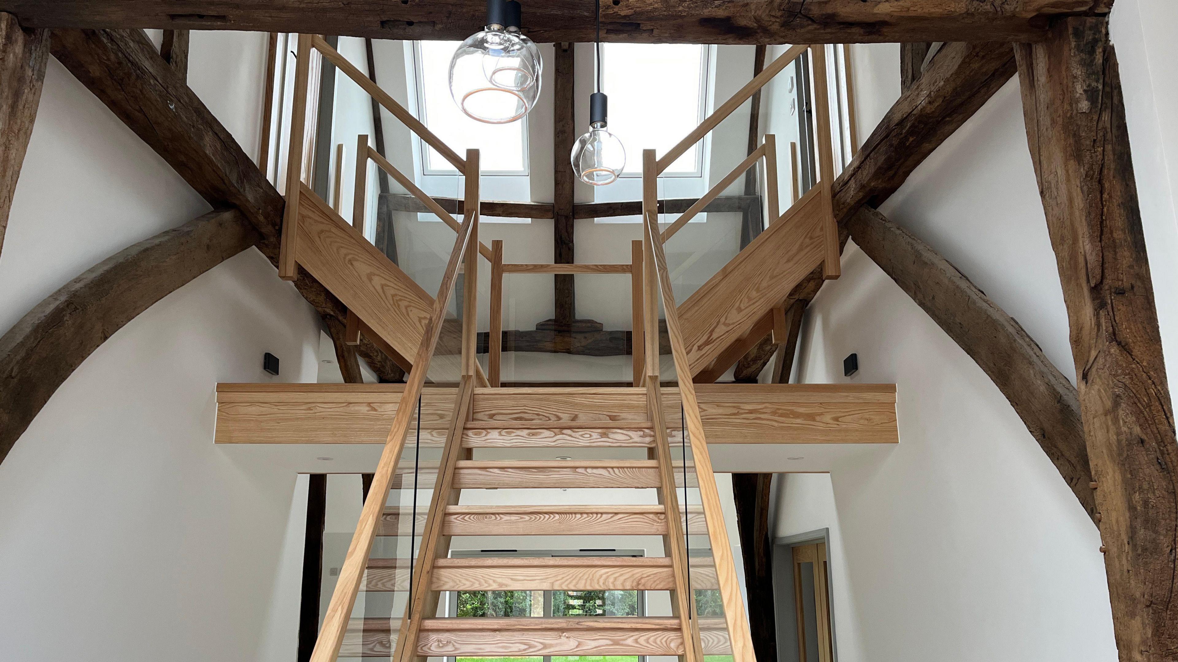 A view of the barn's wooden staircase. It is framed by wooden beams.
