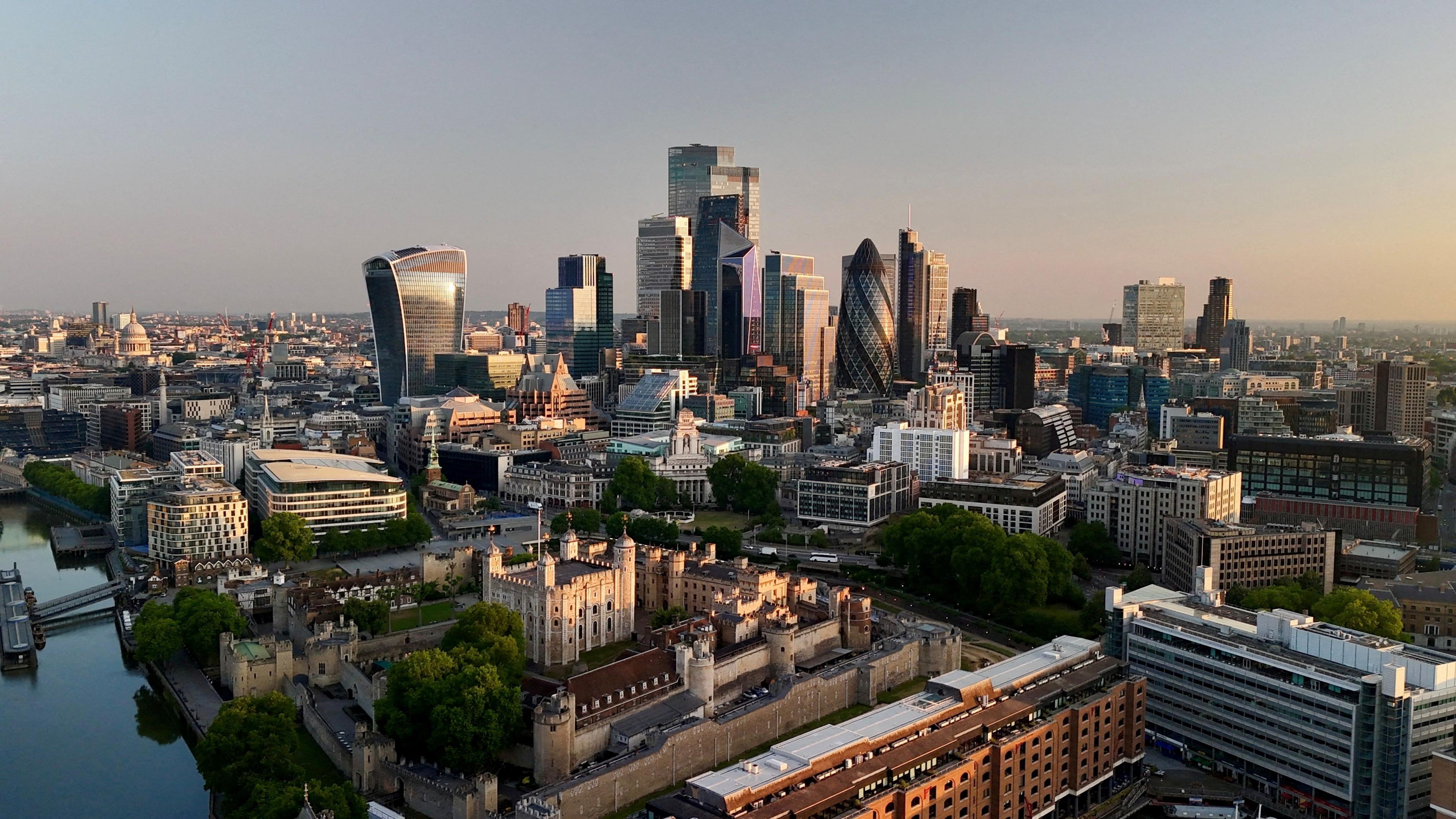 Day breaks over the City of London, with buildings visible including the Walkie Talkie and the Gherkin.