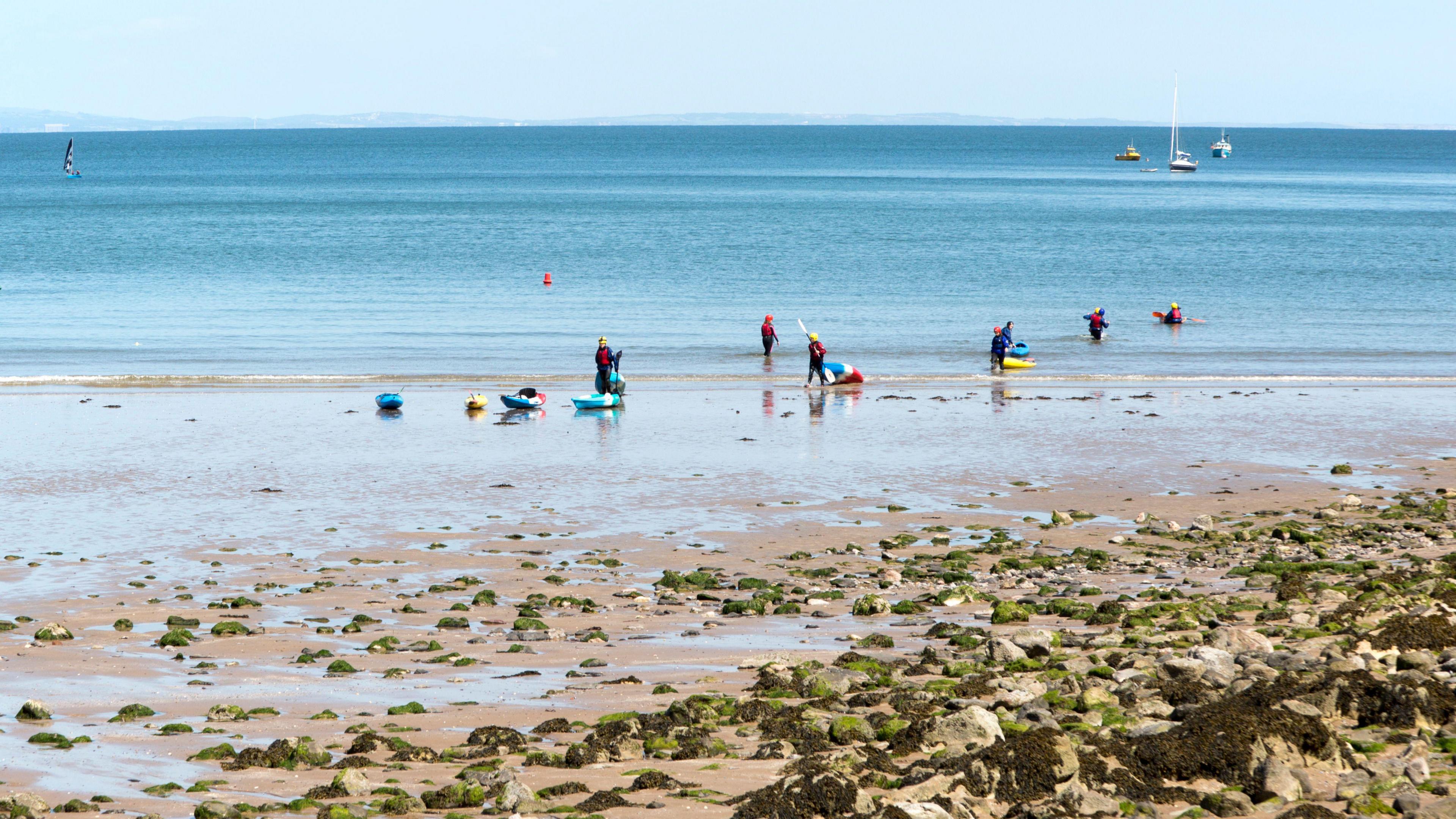 Several people enjoy water sports at Oxwich bay