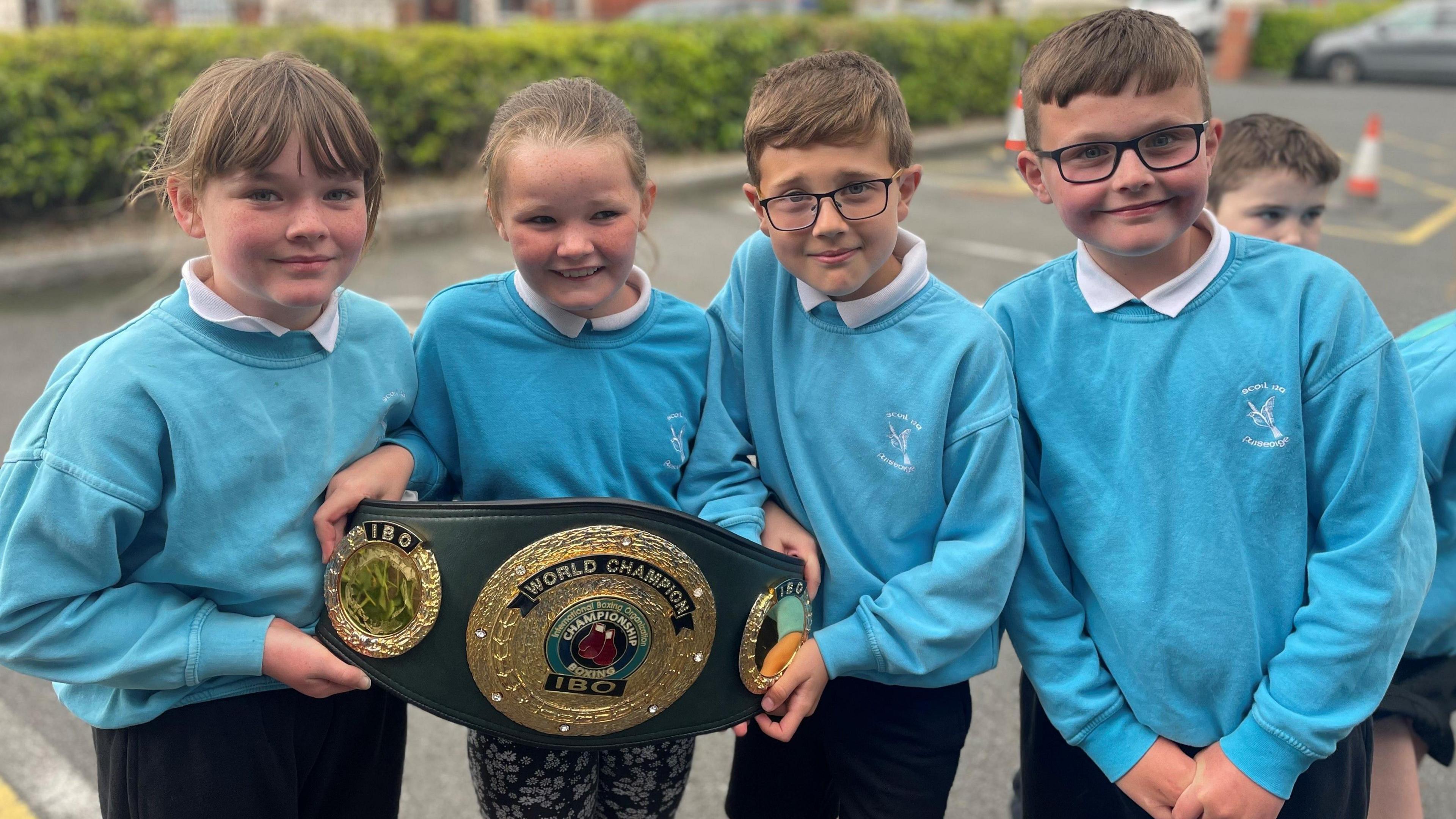 School kids holding Cacace's belt