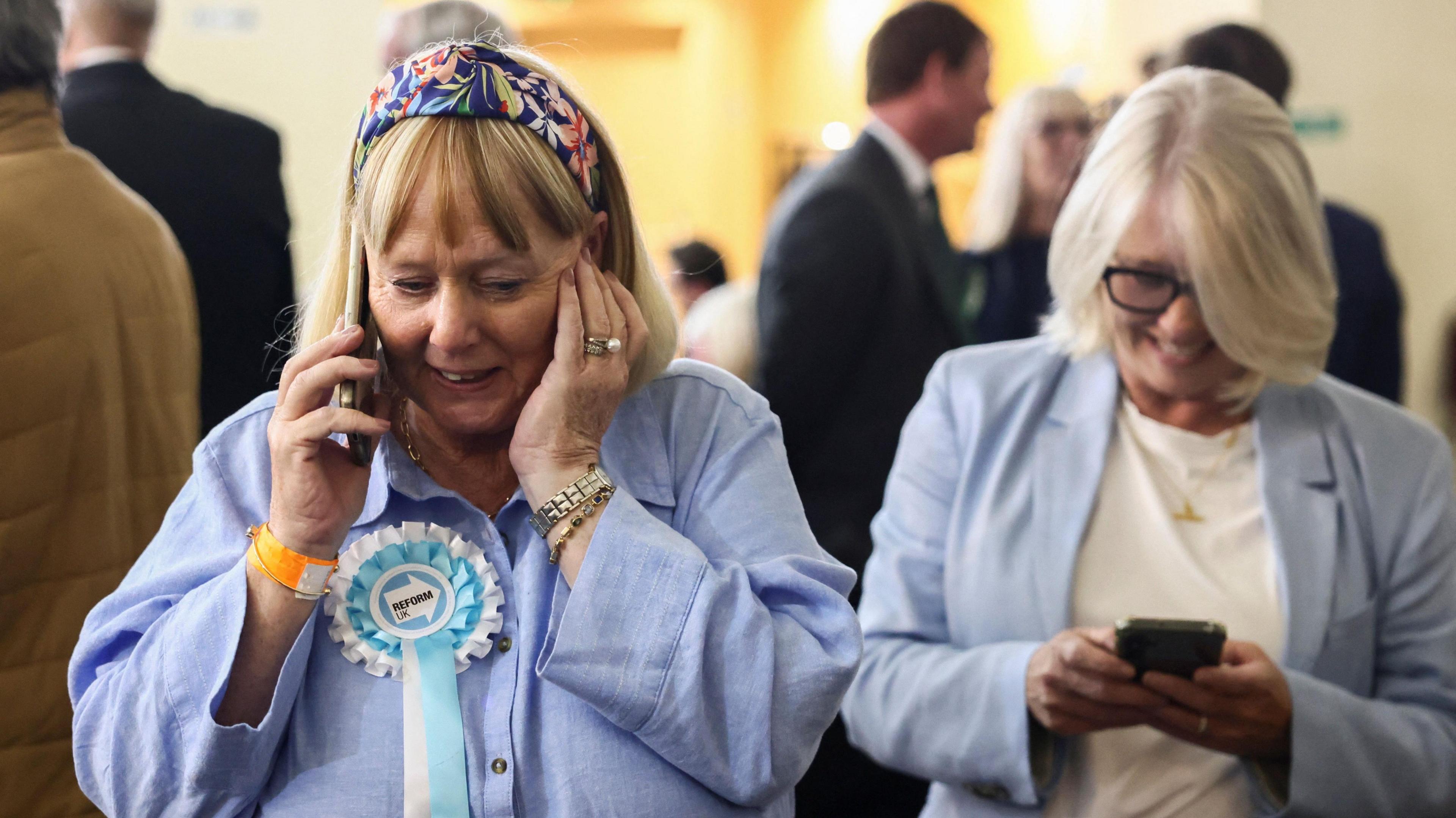 a woman on the phone wearing a reform UK 