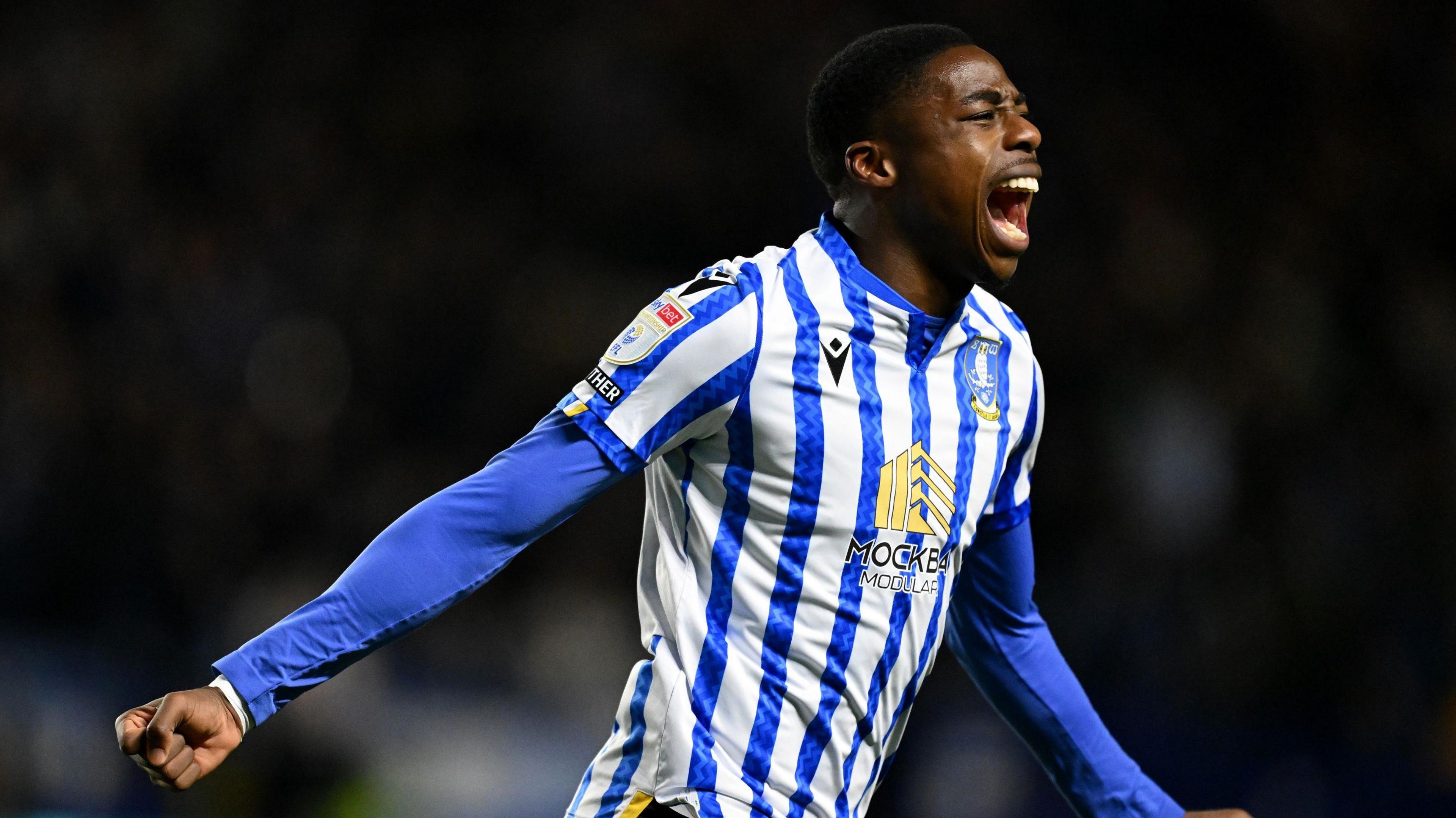 Anthony Musaba celebrating in a Sheffield Wednesday blue and white striped home shirt during their match against Derby in January 2025