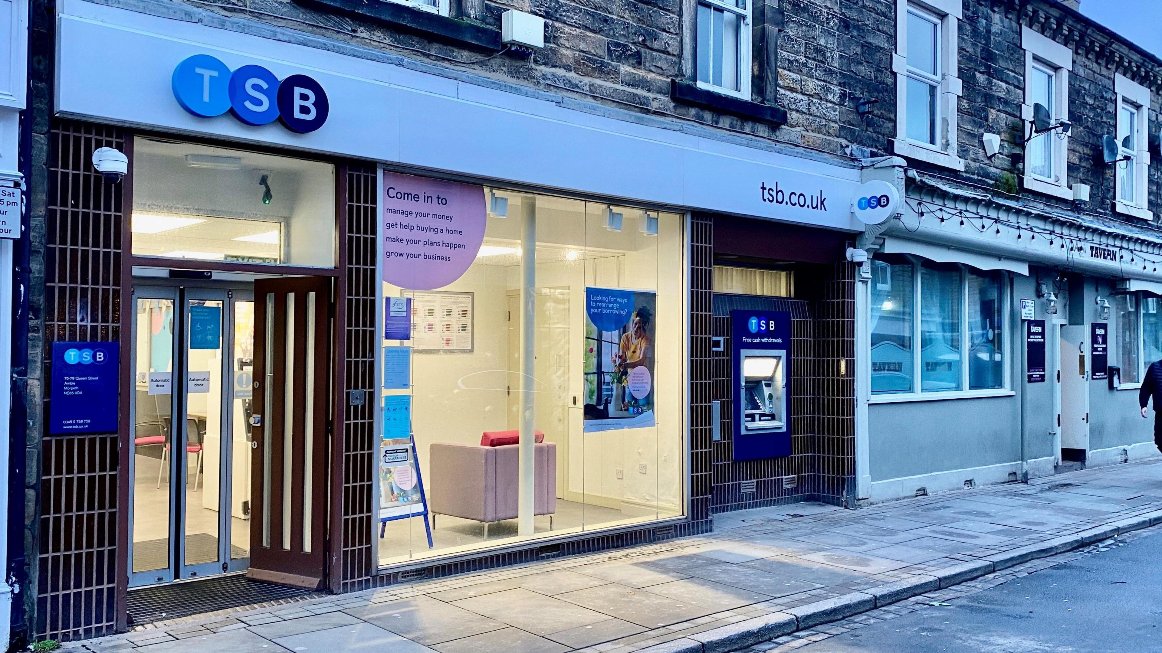 A branch of TSB on Amble High Street with a cashpoint to one side and a pub next door 