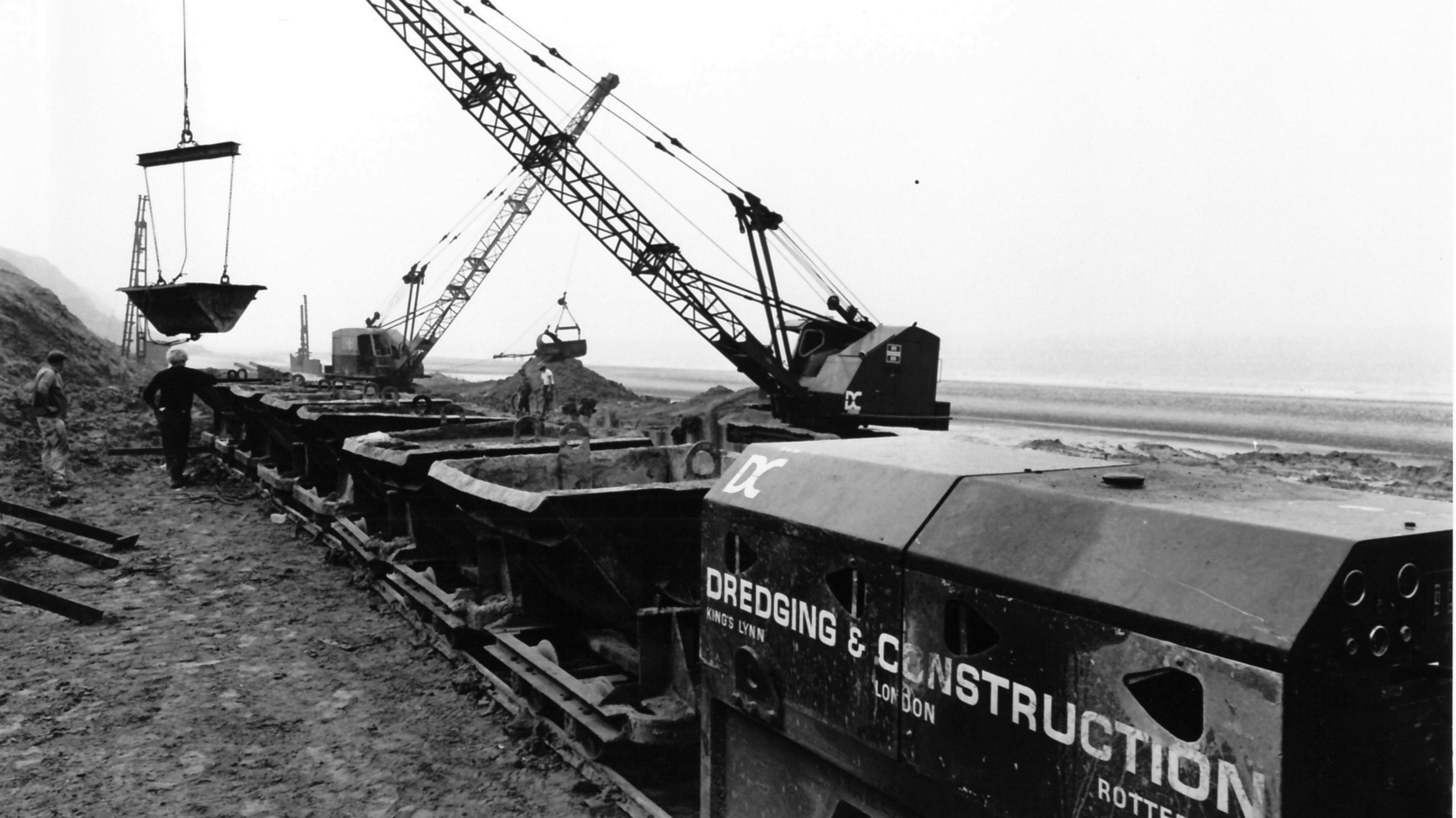 A photo taken in 1973 showing a train on tracks at Trimingham beach with cranes lifting materials from the train