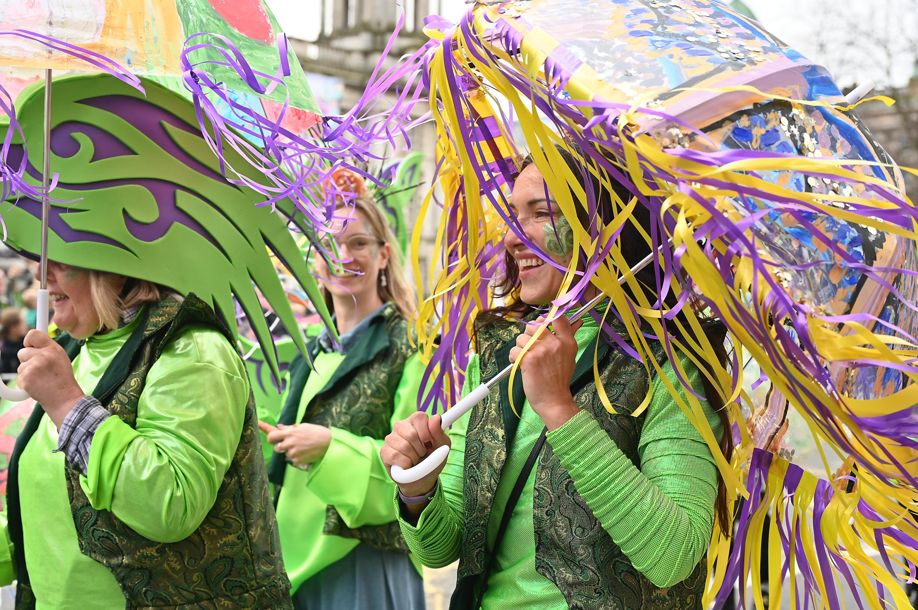 women in green surrounded by purple and yellow ribbons